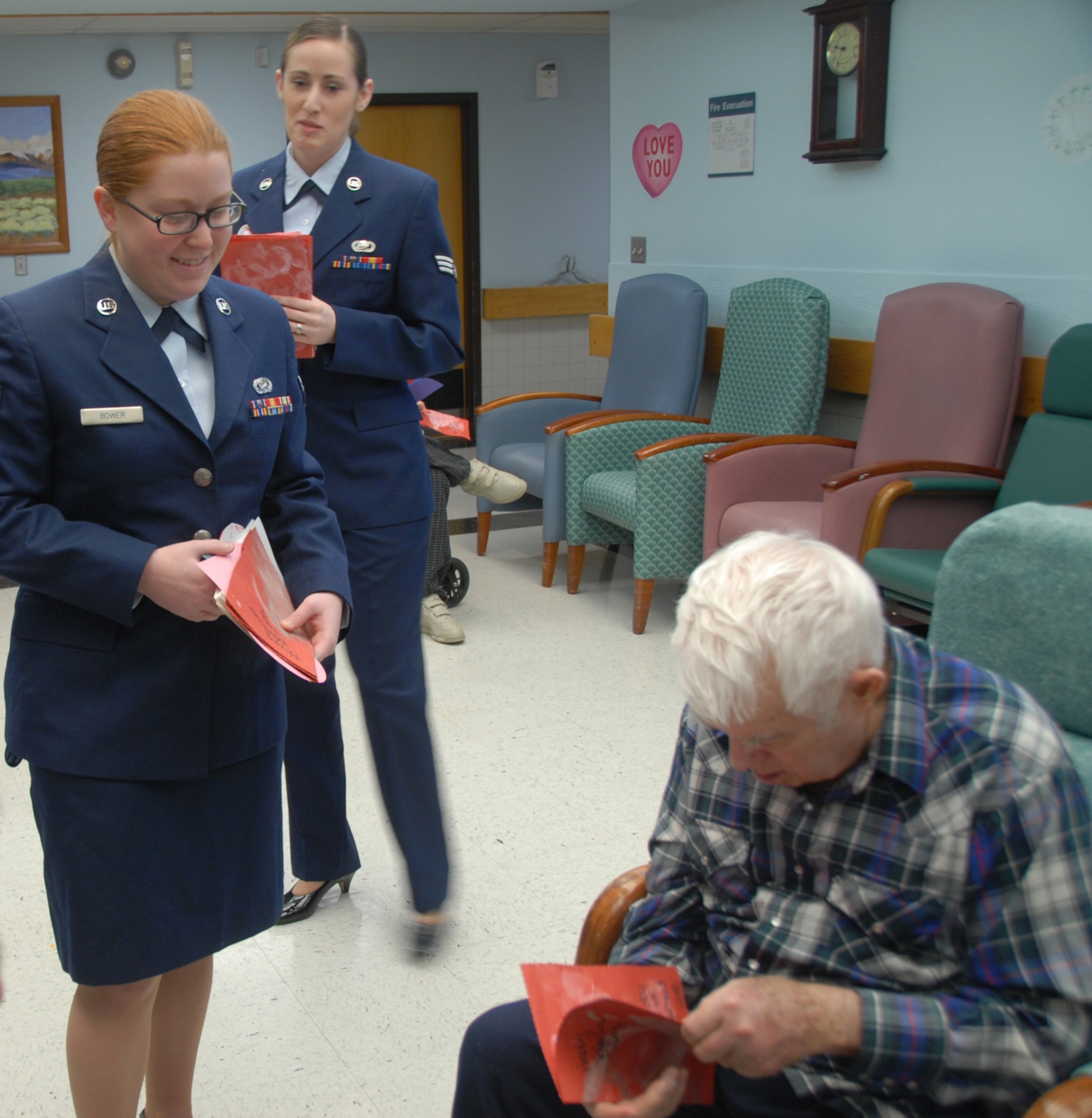 ALTUS AIR FORCE BASE, Okla. -- From left, Airman 1st Class Amanda Bower, 97th Air Mobility Wing Public Affairs and Senior Airman Heather Holihan deliver a valentine to a veteran during the annual Valentine's for Vets visit to the Oklahoma Veterans Center in Clinton, Okla. Approximately 70 Airmen and civilians spent time with veterans at various retirement homes around Altus. (U.S. photo/Airman 1st Class Jennifer Flores)