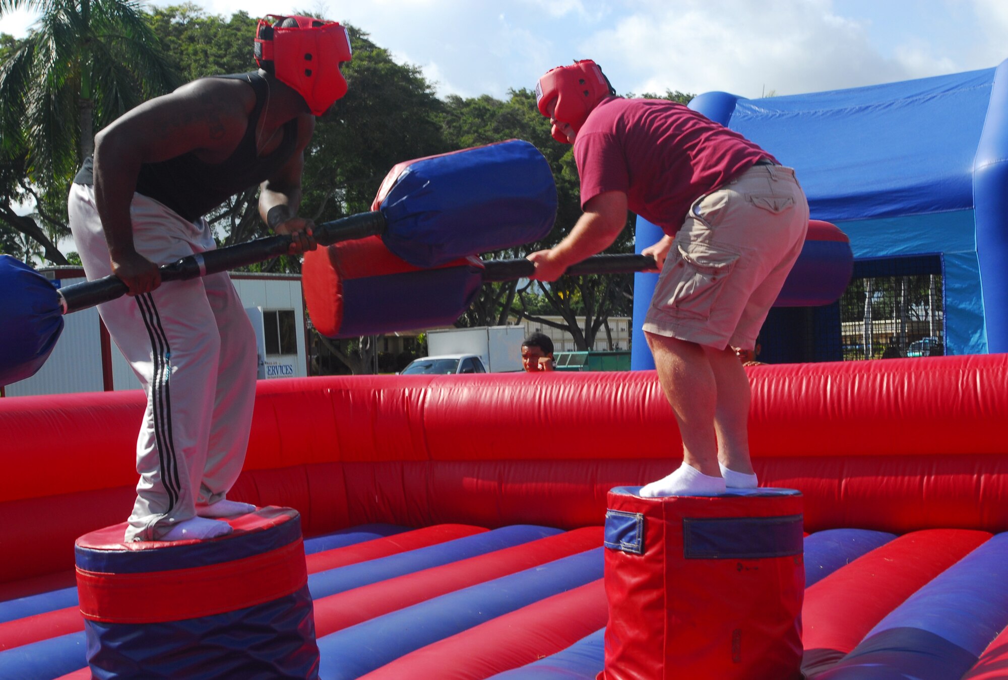 Staff Sgt. Jamell Collins, left,  Det. 2, 18th Services Squadron, Bellows Air Force Station, and Staff Sgt. Jason Sagan, right, 15th Communications Squadron, fight their way to the top during the Hickam Gladiator jousting competition  during  Mahalofest, Feb. 15 at the Freedom Tower mall. Photo by Staff Sgt. Erin Smith