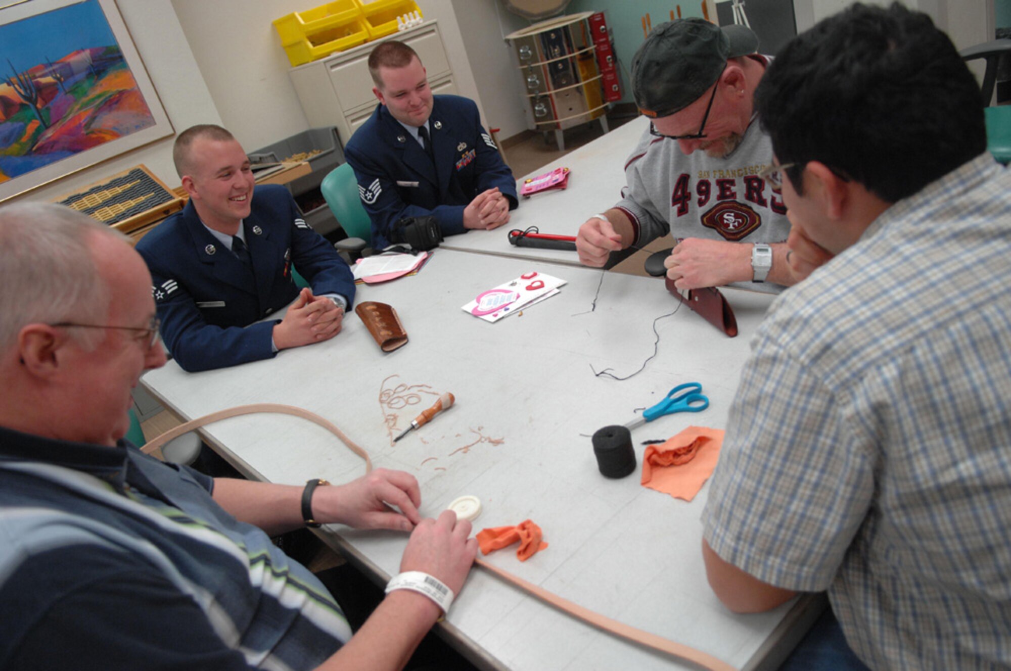 Senior Airman Josh Hull and Staff Sgt. Andrew Smith, 355th Equipment Maintenance Squadron, visit with Army veterans, during their visit to the Tucson VA Medical Center Feb. 14, for the 33rd Annual National Salute to Hospitalized Veterans. The Airmen visited with veterans, and passed out Valentines cards, which were made by Borman Elementary school. (U.S. Air Force photo/SrA Christina D. Kinsey)(RELEASED)