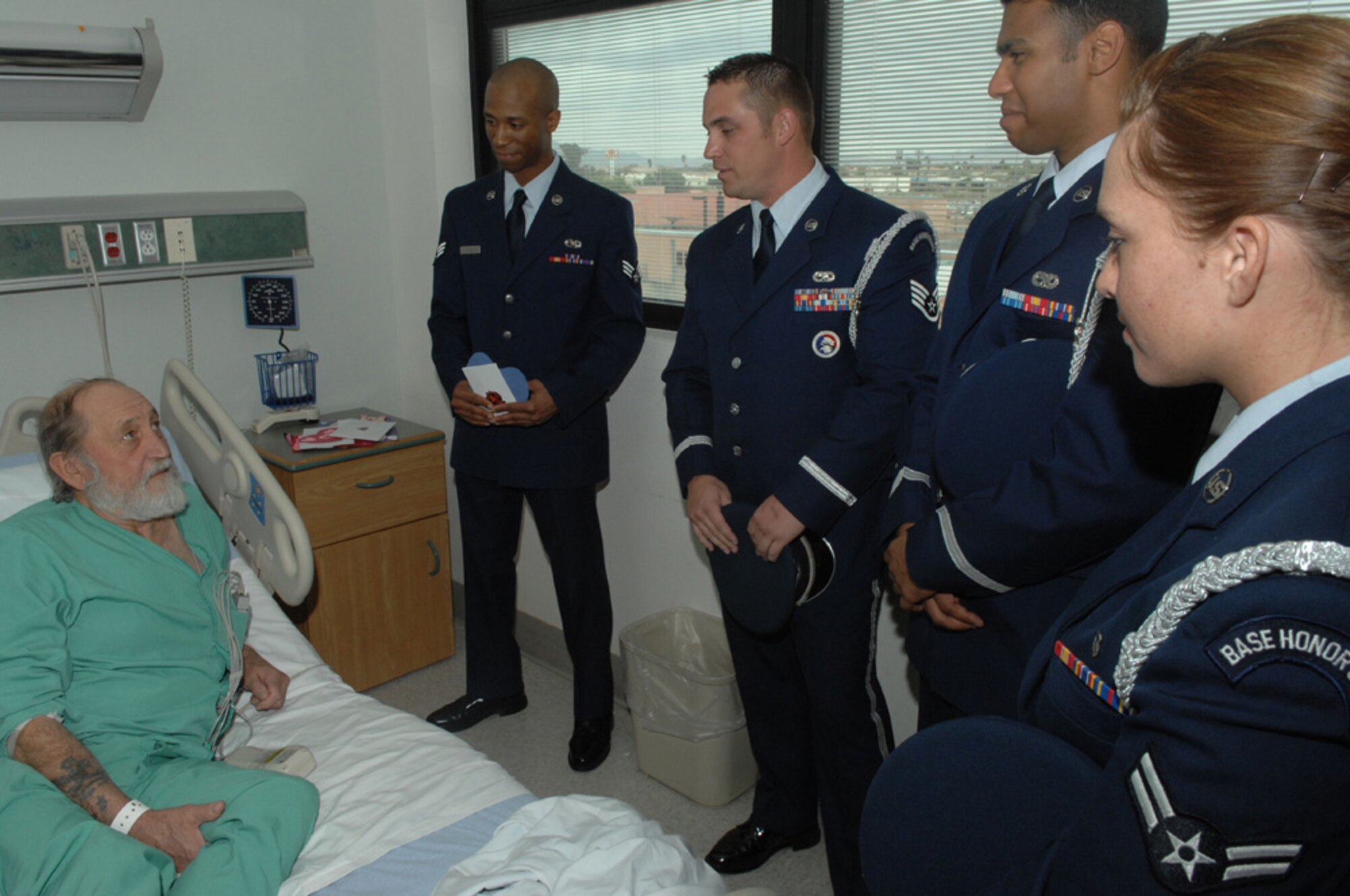 Airmen  from Davis-Monthan AFB speak to Army veteran Maurice Nelson, during their visit to the Tucson VA Medical Center Feb. 14, for the 33rd Annual National Salute to Hospitalized Veterans. The Airmen visited with veterans, and passed out Valentines cards, which were made by Borman Elementary school. (U.S. Air Force photo/SrA Christina D. Kinsey)(RELEASED)