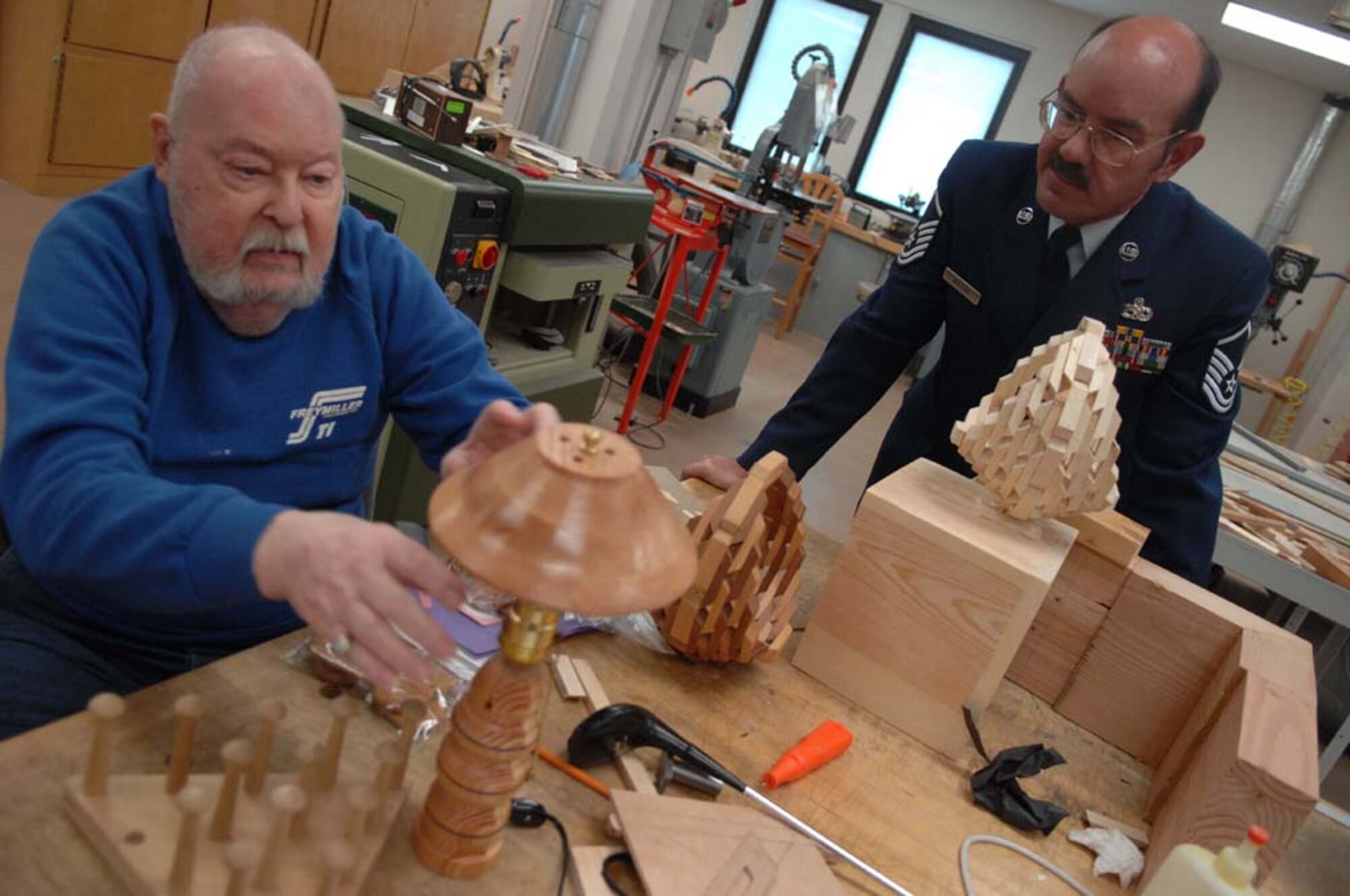 Master Sgt. Peter Wojtak, 355th Equipment Maintenance Squadron, learns about wood working from Army veteran, Charles St. John, during the 33rd Annual National Salute to Hospitalized Veterans, Feb 14th. Airment from Davis-Monthan AFB visited with veterans, and passed out Valentines cards, which were made by Borman Elementary school. (U.S. Air Force photo/SrA Christina D. Kinsey)(RELEASED)