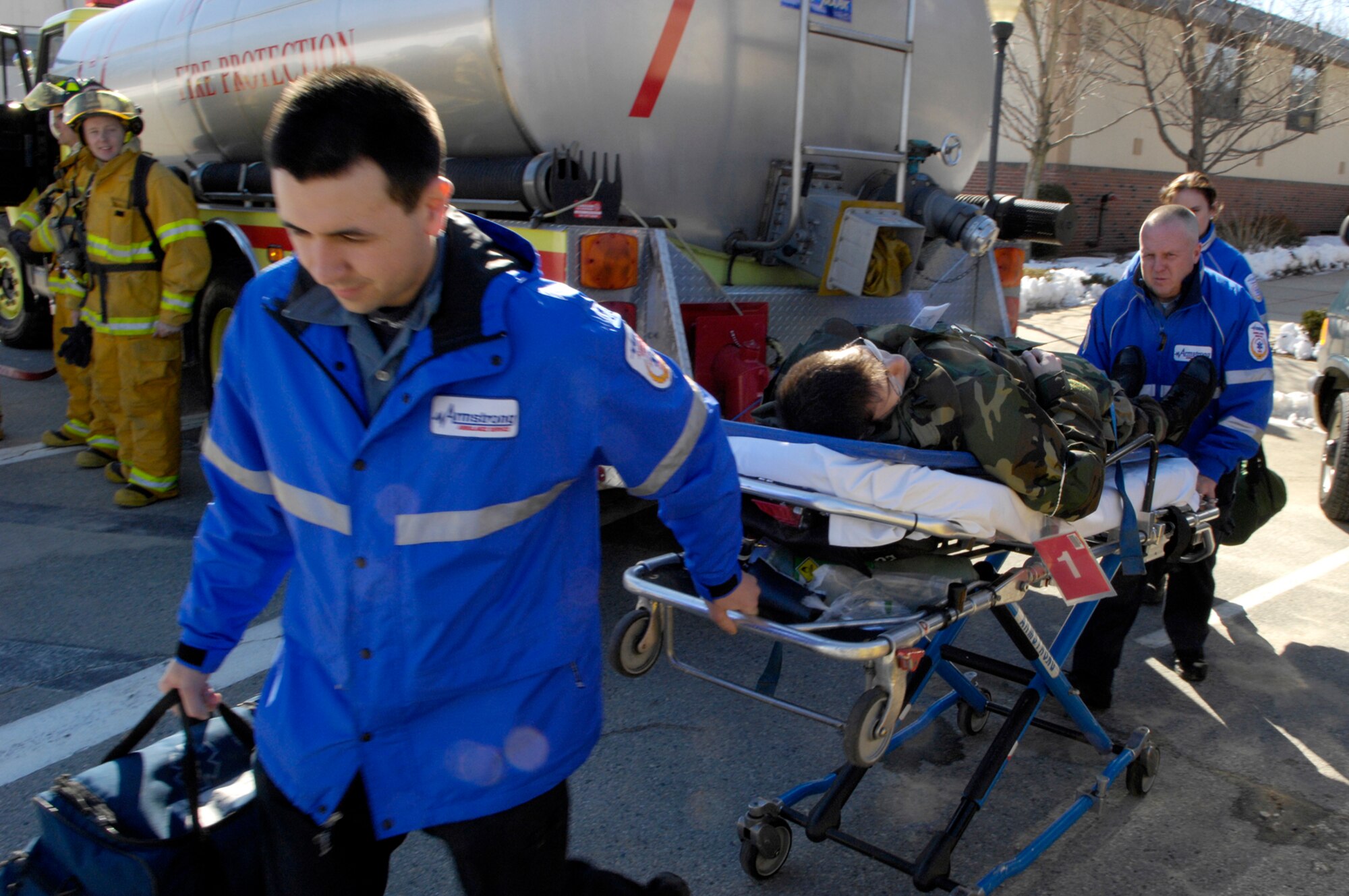 HANSCOM AFB, Mass. -- Employees of Armstrong Ambulance wheel a mock casualty from the scene during an exercise Feb. 14 that tested the base’s response to a chemical attack. The exercise was part of three days of All Hazard Response Training at Hanscom provided by a team contracted by the Department of Defense. Representatives from nearby Emerson Hospital and the Massachusetts Department of Public Health joined in the training along with people from Armstrong Ambulance and a number of base agencies. (U.S. Air Force photo by Mark Wyatt)