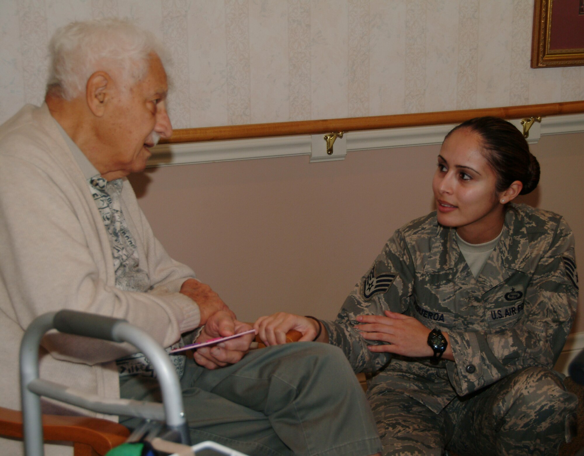 Staff Sgt. Iris Figueroa, 68th Electronic Warfare Squadron, listens to Army veteran Paul Feb. 14 at the Sterling House in Niceville Fla.  More than 50 active duty 53d Wing members presented vets in nursing homes around the local area with cards and candy on Valentine's Day.  U.S. Air Force photo by Master Sgt. Andrew Leonhard.  
