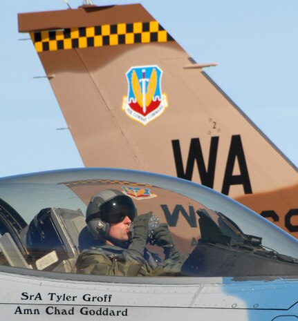 NELLIS AIR FORCE BASE, Nev. - Maj. Todd Robbins, an F-16 Fighting Falcon pilot from the 64th Aggressor Squadron here, grabs a quick drink during an end-of-runway check before a Red Flag mission here Feb. 12. Red Flag is a multi-national exercise providing pilots with a realistic environment to practice combat scenarios. The experience gained during Red Flag is vital to the survival of pilots in combat. (U.S. Air Force photo by Chief Master Sgt. Gary Emery)