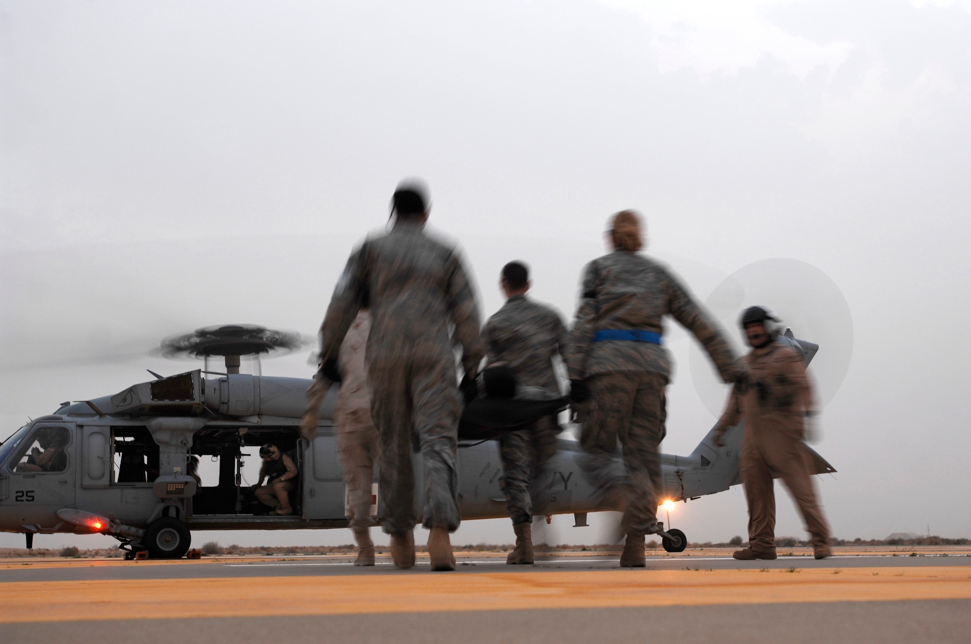 SOUTHWEST ASIA -- Members from the 386th Expeditionary Medical Group move a litter toward an U.S. Navy MH-60 Sierra helicopter during litter management system training at an air base in the Persian Gulf Region Feb. 18, 2008. The training familiarizes medical personnel on the loading and extracting techniques of patients for medical evacuation missions in support of Operations Enduring and Iraqi Freedom.  (U.S. Air Force photo/ Staff Sgt. Patrick Dixon)
