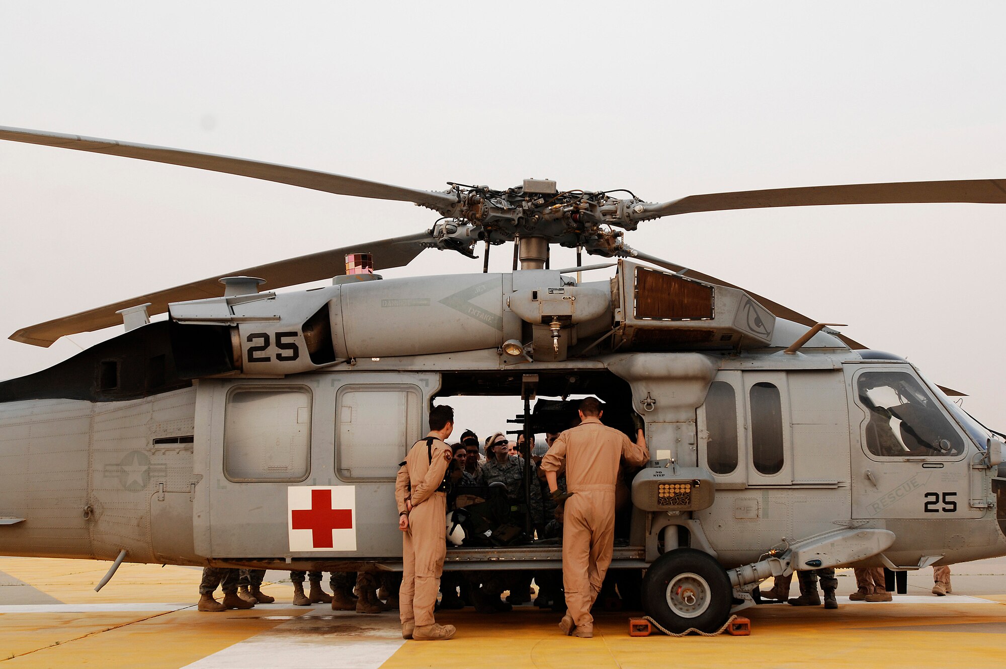 SOUTHWEST ASIA -- U.S. Navy Aviation Warfare Specialists 3rd Class (AW3) Eric Uhden (left) and AW2 Jordan Schuster (right) peer through an open door of a MH-60 Sierra helicopter while members from the 386th Expeditionary Medical Group are being trained on the litter management system of the Sierra at an air base in the Persian Gulf Region Feb. 18, 2008.  The training familiarizes medical personnel on the loading and extracting techniques of patients for medical evacuation missions in support of Operations Enduring and Iraqi Freedom. (U.S. Air Force photo/ Staff Sgt. Patrick Dixon)