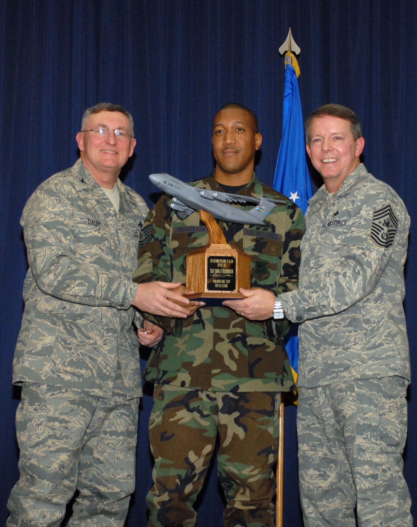 Col. Dennis Daley, 436th Maintenance Group commander, Tech. Sgt. Jamal Richardson, 436th Aircraft Maintenance Squadron, and the Chief Master Sgt. of the Air Force Rodney J. McKinley, gather on stage at the 2008 Maintenance Professional of the Year Banquet at The Landings Club on Dover Air Force Base, Feb. 11. Colonel Daley and Chief McKinley presented Sergeant Richardson a C-5 trophy as he was named the Air Mobility Command-level Outstanding MX Pro of the Year in the NCO category. (U.S. Air Force photo/Tech. Sgt. Kevin Wallace)
