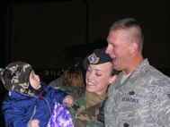 SEYMOUR JOHNSON AIR FORCE BASE, N.C. -- Tech. Sgt. Dan Paus greets his son, Connor, and wife, Staff Sgt. Brittany Paus, upon returning from a six-month deployment to Iraq.  Both are members of the 916th Air Refueling Wing Security Forces Squadron. U.S. Air Force photo/Capt. Shannon Mann