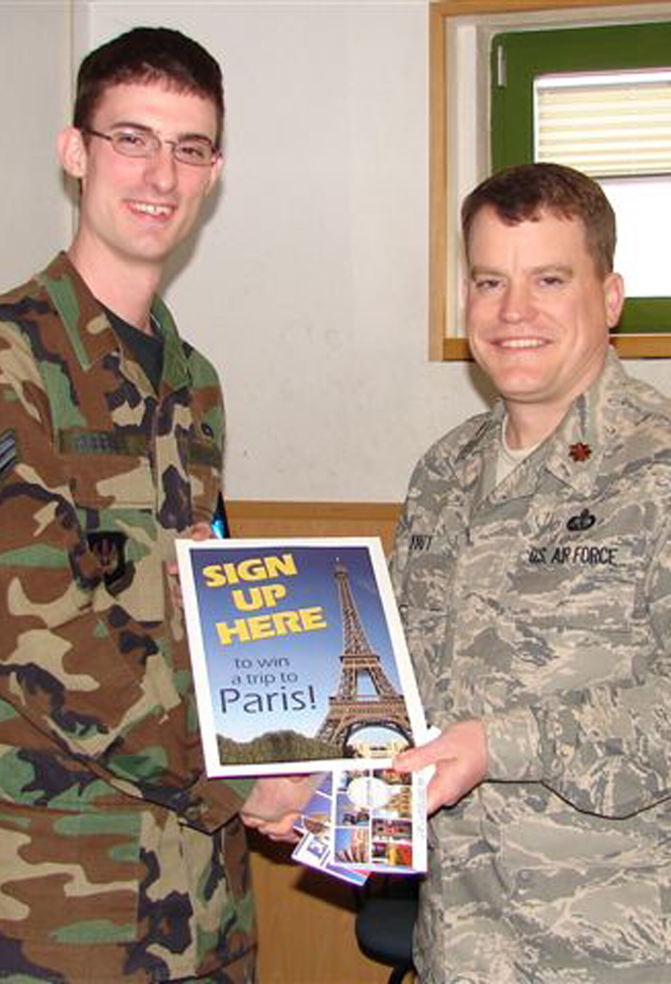 SPANGDHALEM AIR BASE, Germany – Maj. Michael Wyatt, 52nd Services Squadron commander, presents a trip for two to Paris to Senior Airman Jonathan Robbins, 52nd Equipment Squadron, a grand prize in the ongoing 52nd SVS UPICKEM Program. (Photo courtesy of 52nd Services Marketing Department)