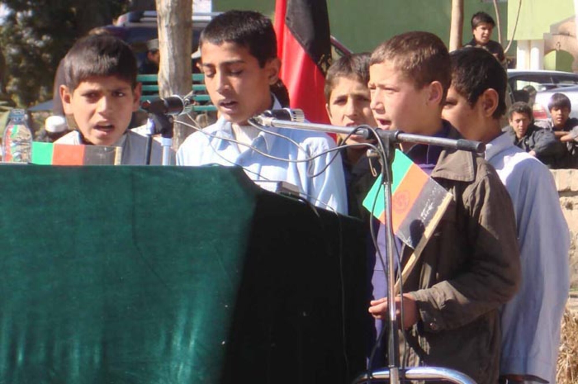 LAGHMAN PROVINCE, Afghanistan--Several Afghan boys from the Gulpacha Ulfat High School sing a poem at a ceremony here Feb. 12. The ceremony was held to celebrate the province’s Qarghaii District being officially declared a "Peace District" by President Karzai's office.  The official announcement was made Feb. 11 and the ceremony was held in the Mehtar Lam Sarag Garden and attended by more than 125 people.  (Photo by Air Force Captain Heather Kekic)