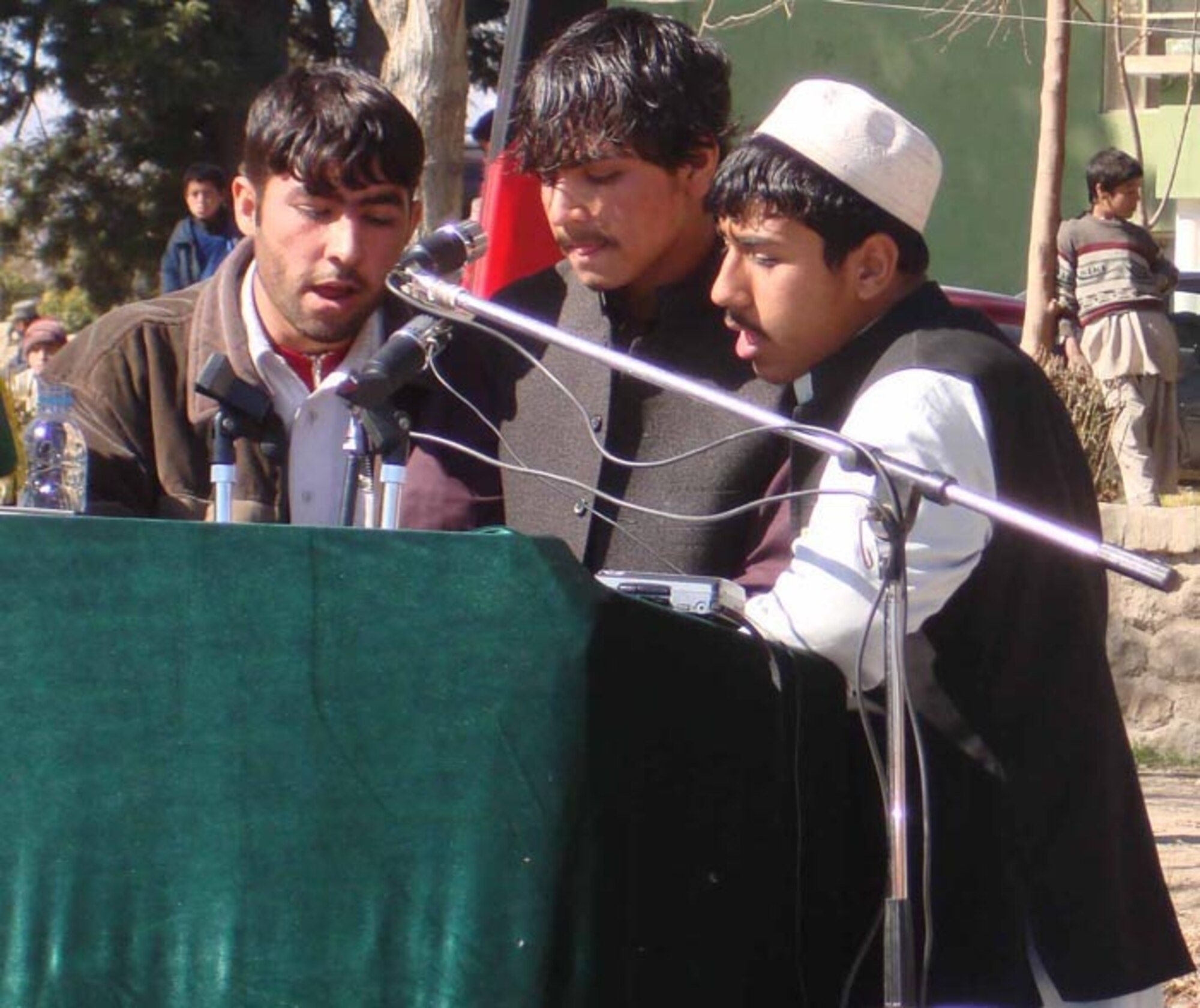 LAGHMAN PROVINCE, Afghanistan--Three Afghan boys from the Eshaq Ningal High School in Mehtar Lam sing a poem at a ceremony Feb. 12. The ceremony here was held to celebrate the province’s Qarghaii District being officially declared a "Peace District" by President Karzai's office.  The official announcement was made Feb. 11 and the ceremony was held in the Mehtar Lam Sarag Garden and attended by more than 125 people.  (Photo by Air Force Captain Heather Kekic)
