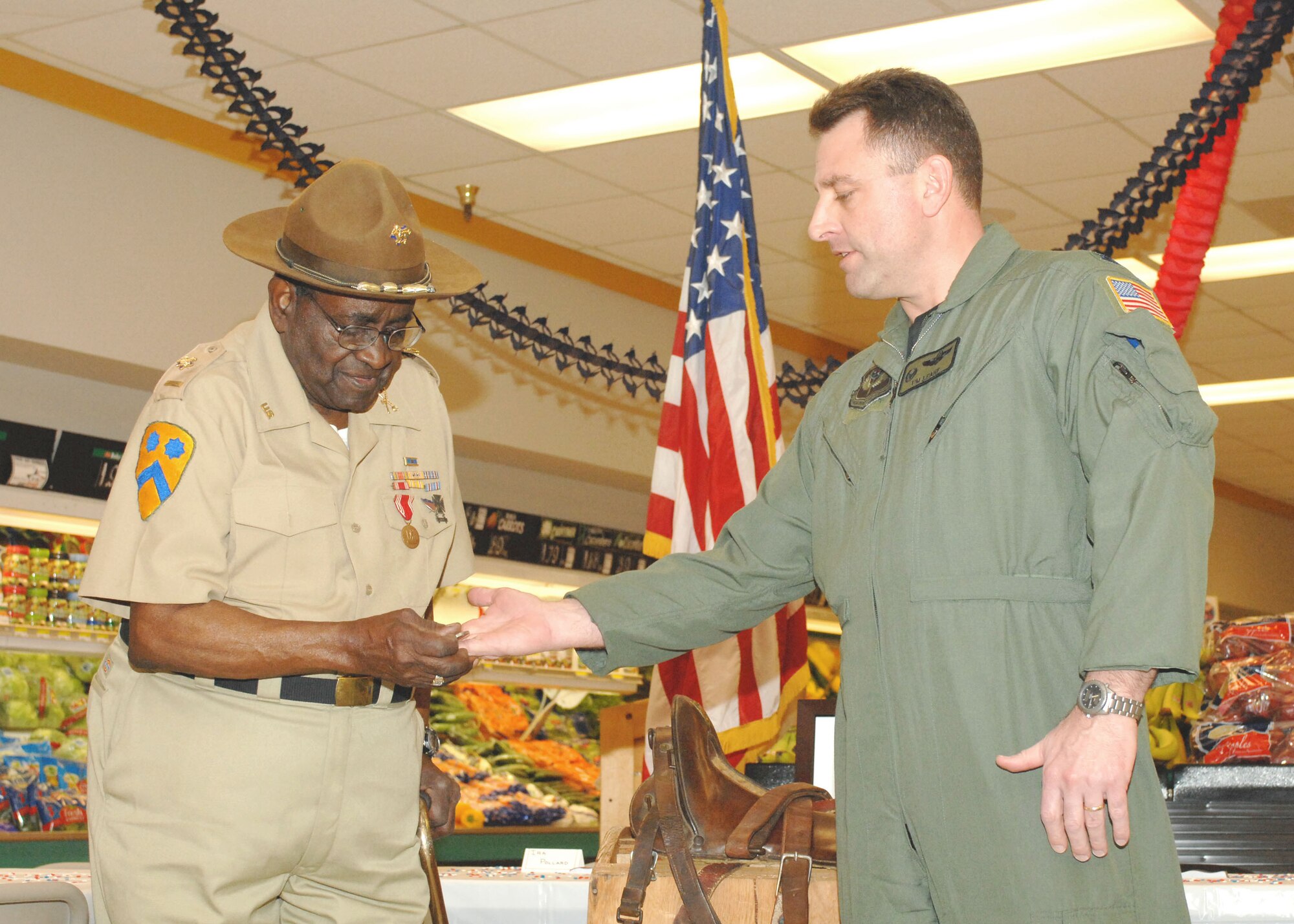 CANNON AIR FORCE BASE N.M.- Colonel Timothy Leahy presents Ira Pollard with the commanders coin Feb. 20.  Mr. Pollard is the last living Buffalo Soldier in New Mexico.  (U.S. Air Force photo by A1C James R. Bell)