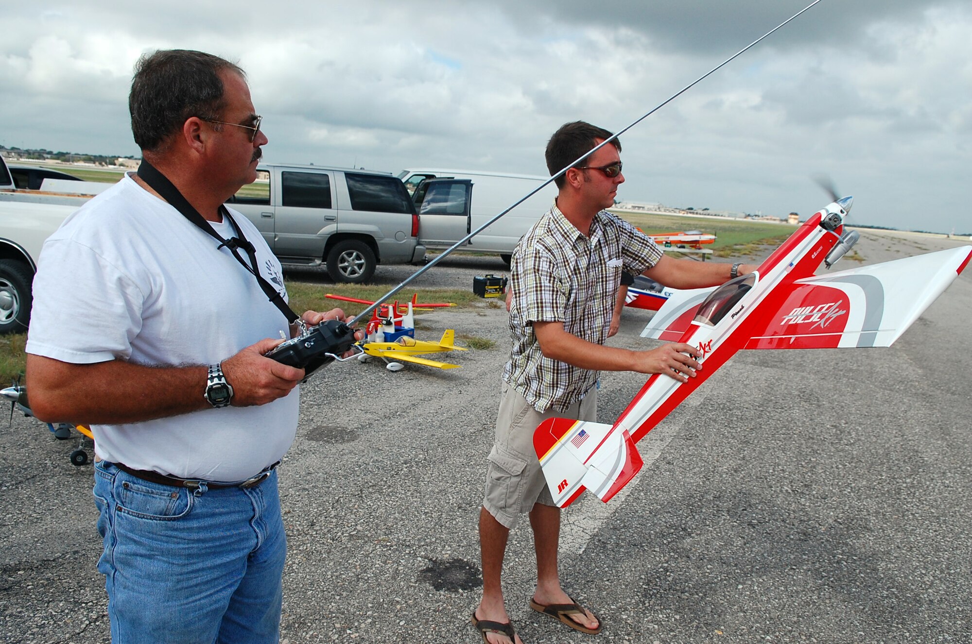 LAUGHLIN AIR FORCE BASE, Texas – Ted Glenn, lead T-1 simulator instructor here, and 1st Lt. Nick Burik, 85th Flying Training Squadron, test out a gas-powered model airplane before flying it at an old runway on the Laughlin airfield.  Both are members of the Del Rio Dirt Flyers, a small group of radio-control aviation enthusiasts who fly at Laughlin when the airfield is closed.  (U.S. Air Force photo by Staff Sgt. Austin M. May)