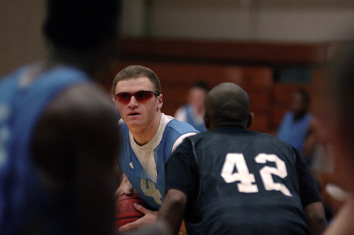 Flyers player Dean Neistat looks for an open teammate while Medical Group player Adam Garrett defends him during their intramural basketball game Feb. 19 at the Fitness and Sports Center. (U.S. Air Force photo/Senior Airman Nicholas Pilch)