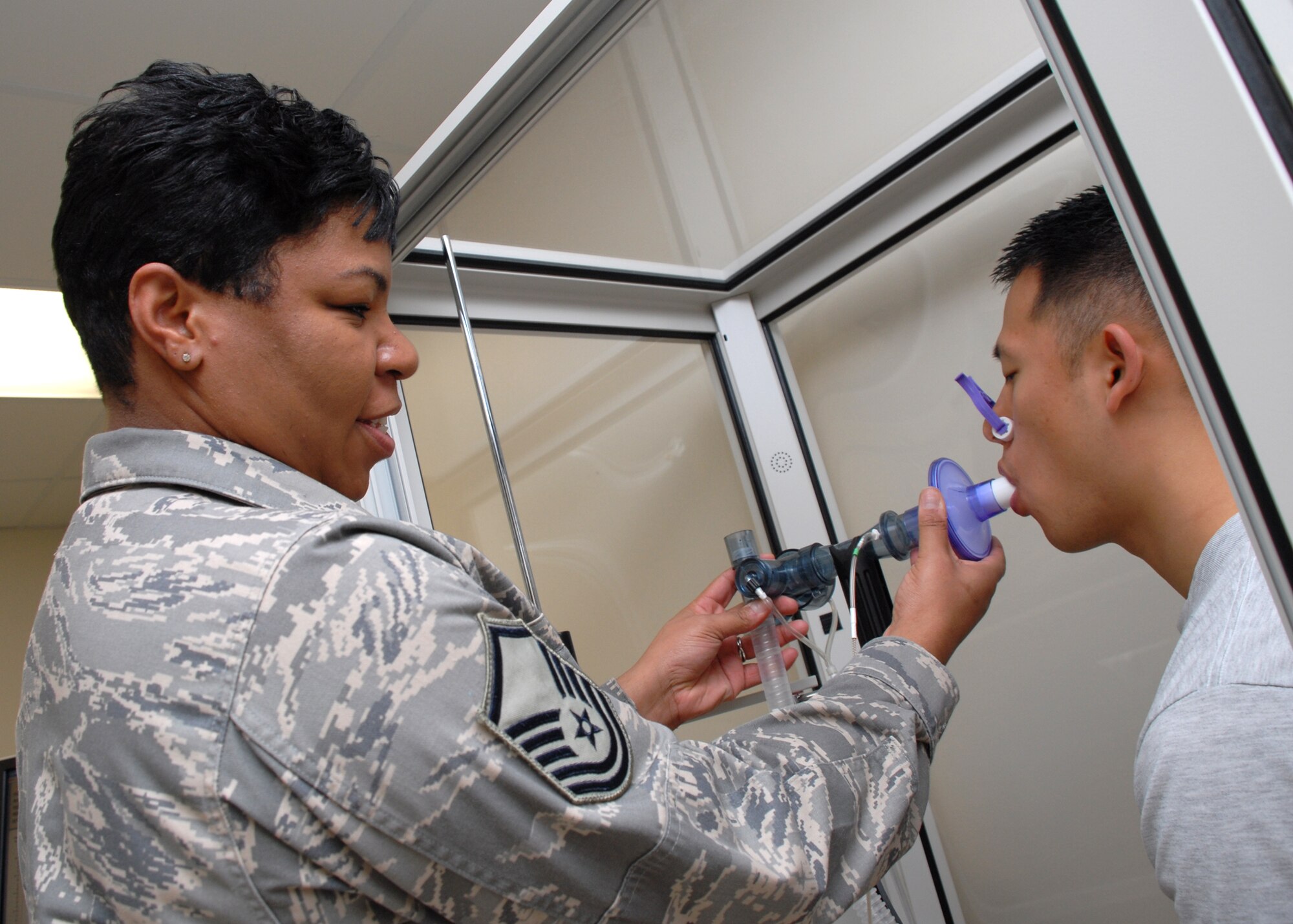EGLIN AIR FORCE BASE, Fla. -- Master Sgt. Melissa L. Gee, 96th Medical Operations Squadron NCO in charge of pulmonary diagnostics, conducts a lung capacity test on Senior Airman Yung Kim. Sergeant Gee was recently awarded the U.S. Air Force John Salustro Memorial Award for Cardiopulmonary Excellence. Among her many accomplishments, she procured the region's sole cauterizing bronchoscopy machine, helping stop life threatening lung bleeds in three patients. Sergeant Gee graduated with an associates degree in Cardiopulmonary Laboratory Science and is working toward a bachelors degree in Health Sciences. She is an active member in a local Parent Teacher Association and participated in the American Cancer Society's Relay for Life event. (U.S. Air Force photo by Staff Sgt. Mike Meares)