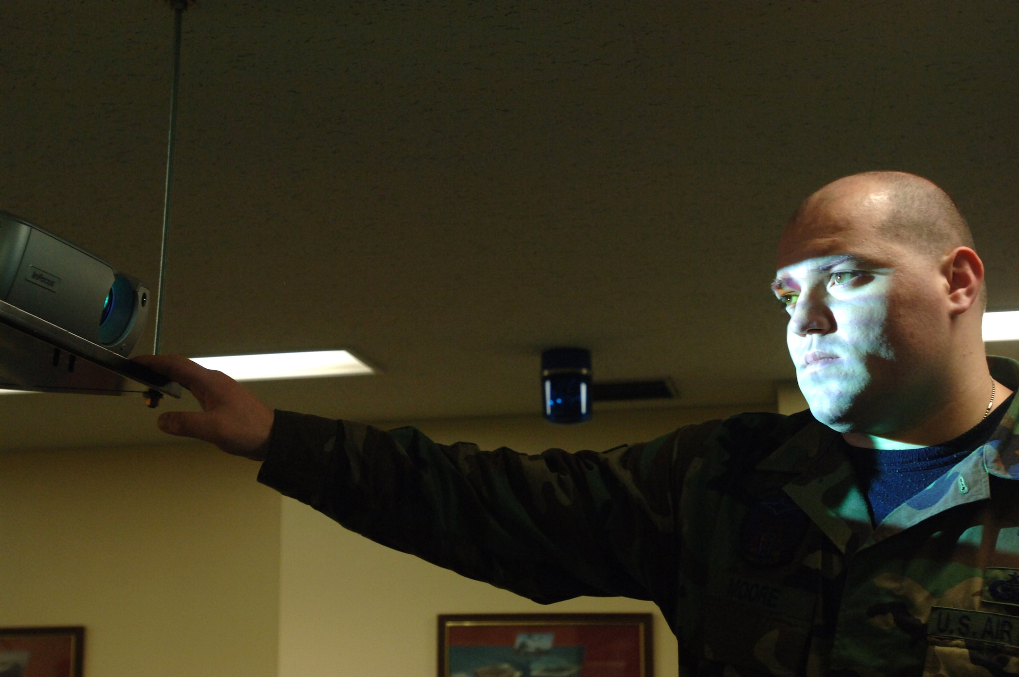 Staff Sgt. Mark Moore adjusts a projector prior to giving a briefing Feb. 19 at Misawa Air Base, Japan. While off-duty recently, Sergeant Moore came across and helped a Japanese woman who was injured from a car accident and had her vehicle flipped over. He is assigned to the 35th Operations Support Squadron. (U.S. Air Force photo/Senior Airman Robert Barnett) 
