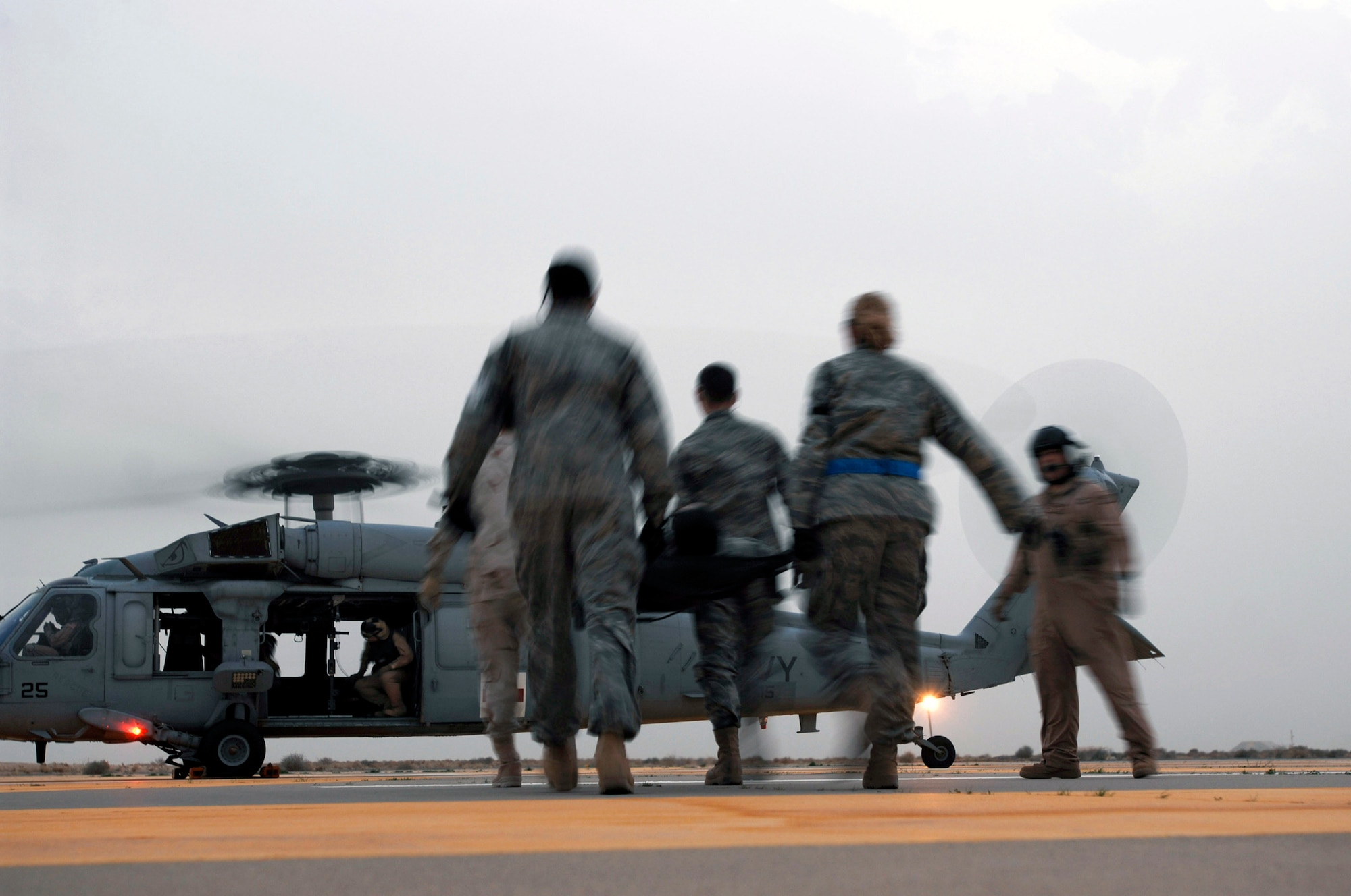 Airmen from the 386th Expeditionary Medical Group move a litter toward a Navy MH-60 Sierra during litter management system training Feb. 18 at a Southwest Asia air base. The training familiarized medics on the loading and extracting techniques of patients for medical evacuation missions in support of operations Enduring Freedom and Iraqi Freedom. (U.S. Air Force photo/Staff Sgt. Patrick Dixon) 

