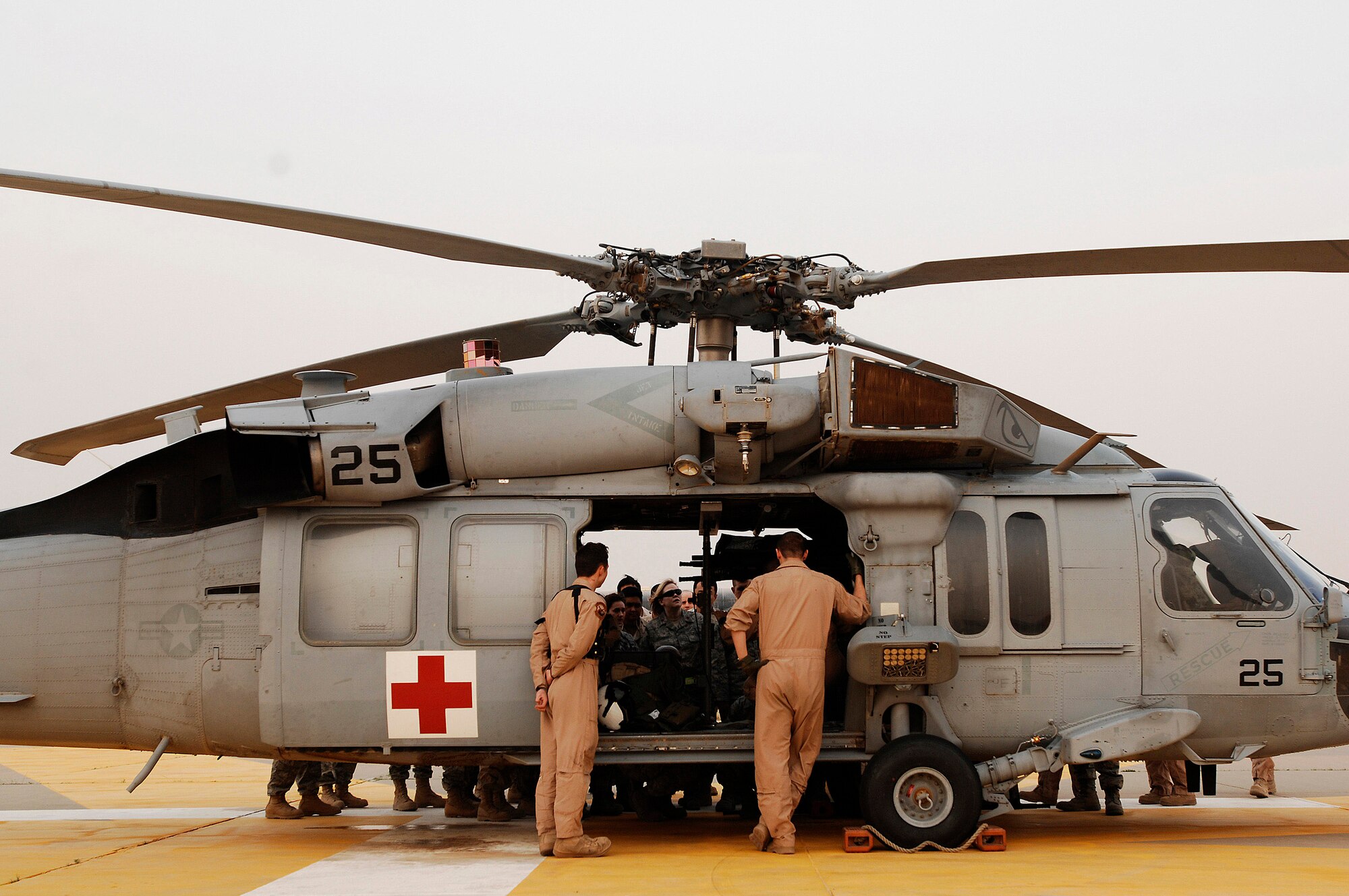 Navy Petty Officer 3rd Class Eric Uhden (left) and Navy Petty Officer 2nd Class Jordan Schuster peer through an open door of a MH-60 Sierra helicopter while Airmen from the 386th Expeditionary Medical Group traind on the litter management system of the helicopter Feb. 18 at a Southwest Asia air base. The training familiarized medics on the loading and extracting techniques of patients for medical evacuation missions in support of operations Enduring Freedom and Iraqi Freedom. (U.S. Air Force photo/ Staff Sgt. Patrick Dixon) 
