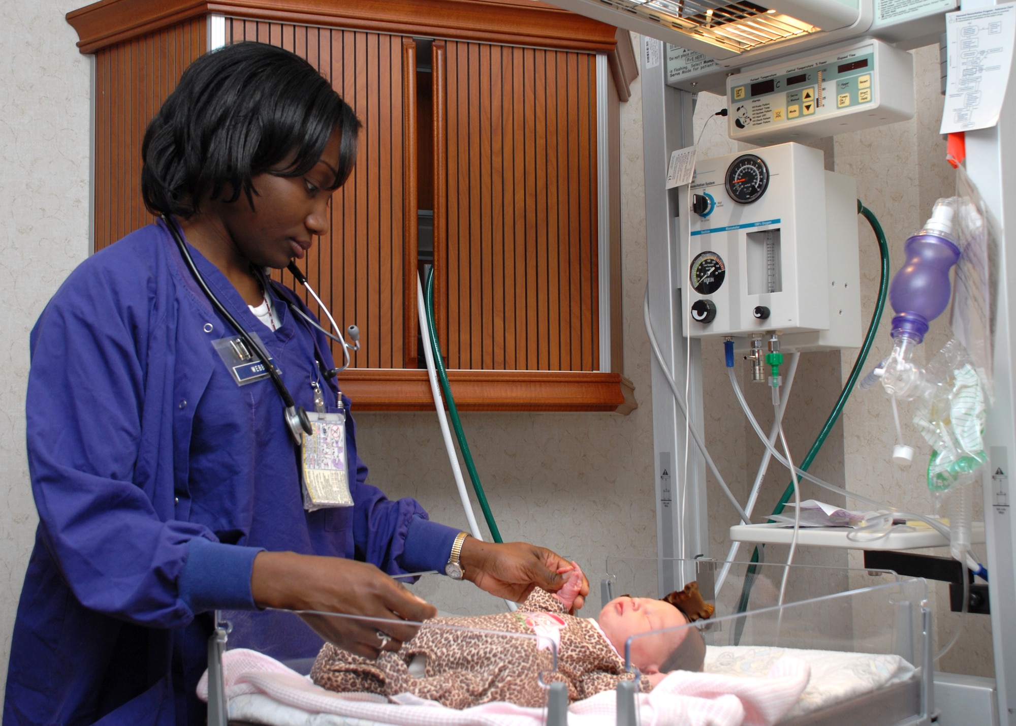 EGLIN AIR FORCE BASE, Fla. -- Capt. Shanita W. Webb, 96th Inpatient Squadron nurse, checks the health status of a newborn baby. She was recently named the U.S. Air Force Maternal Child Nurse of the Year. In the inpatient squadron, she works with a team that averages more than 950 births per year. Captain Webb was instrumental in helping stabilize three unresponsive infants with artificial breathing and resuscitation, averting fetal brain damage. Her attention to detail in training new mothers lessened anxiety and increased confidence when they went home. The captain also volunteers at her church and with the Big Brothers and Big Sisters organization. (U.S. Air Force photo by Staff Sgt. Mike Meares)