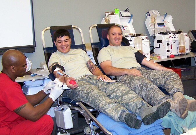 Staff Sgt. Cesar Matos, combat arms instructor in the 99th Ground Combat Training Squadron, and Senior Airman Enrique Garza, aircraft fuel systems journeyman in the 57th Component Maintenance Squadron, donate blood Oct. 9, 2007.  Every ALS student performs at least three hours of community service as part of the course curriculum.  (U.S. Air Force photo) 