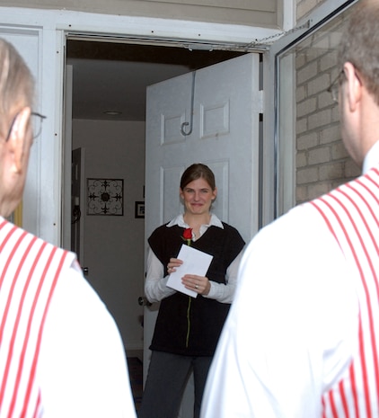Drea Fry receives a "Singing Valentine,? a single rose and a Valentine?s Day card on base Feb. 13 from the Charleston Barbershop Quartet.   Mrs. Fry is the wife of Staff Sgt. Jesse Fry, 437th Logistics Squadron, who is deployed.  The quartet spent the day delivering songs of love to 22 family members of Team Charleston Airmen who were deployed. (U.S. Air Force photo/Staff Sgt. Jennifer Arredondo)