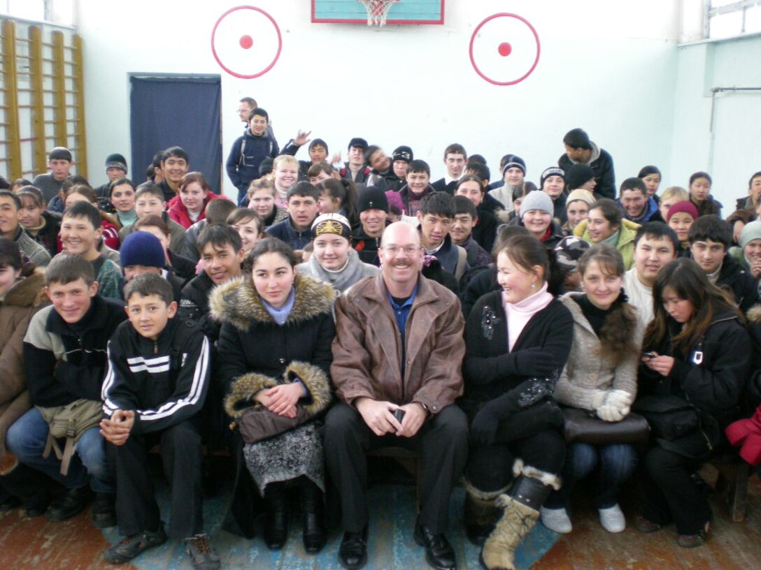 SMSgt Larry Hill, operations direcor for the CENTAF band "Live Round," poses with some Kyrgystani locals during a Spring '08 deployment to Africa and Southwest Asia.
