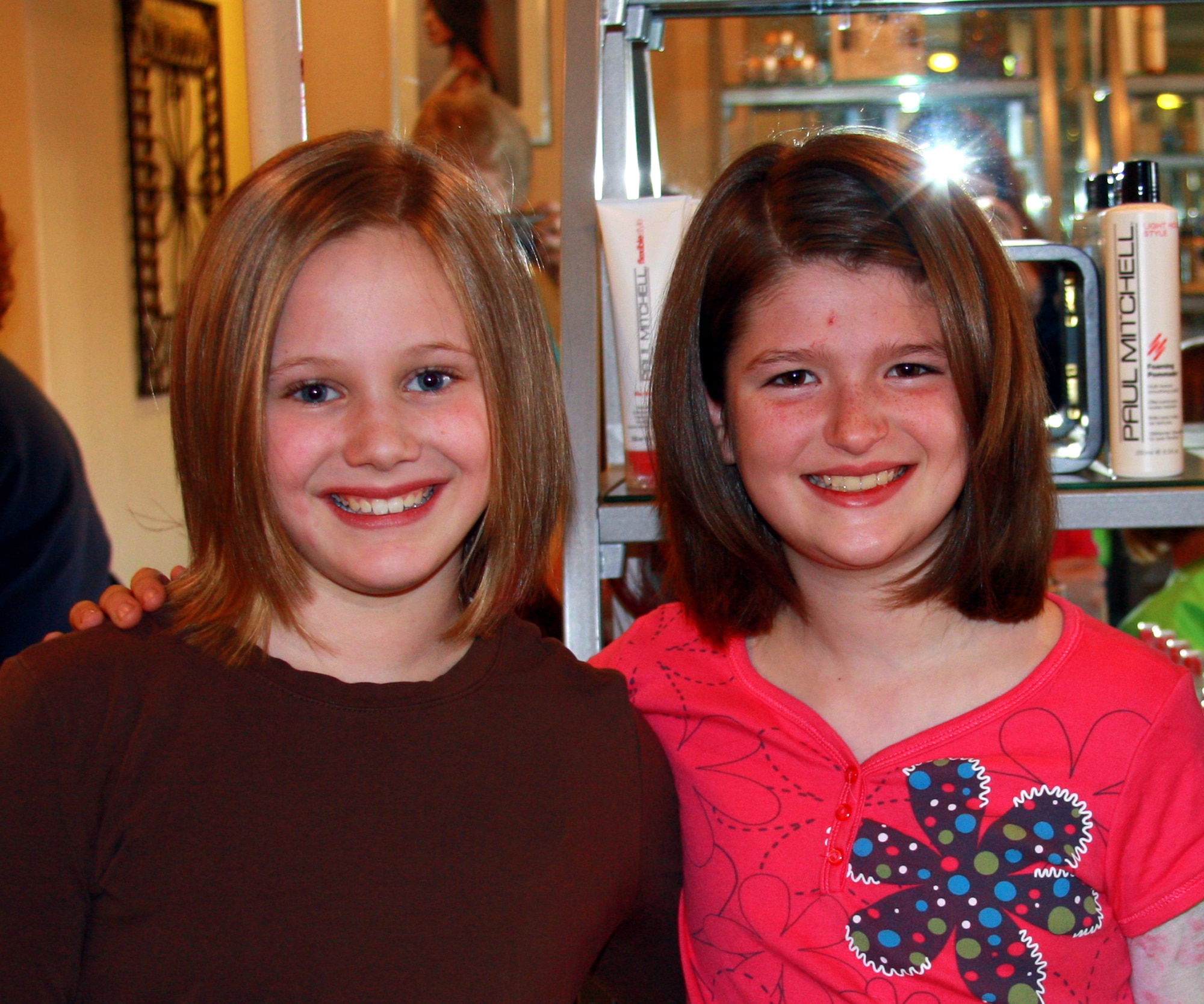 MOUNTAIN HOME AIR FORCE BASE, Idaho -- Leigha Barfield and Kaitlynn Smith are all smiles after cutting their hair Feb. 14 to donate to charities for other children. The girls decided to donate their hair to children suffering from illnesses and going through chemotherapy treatments. (Courtesy photo)