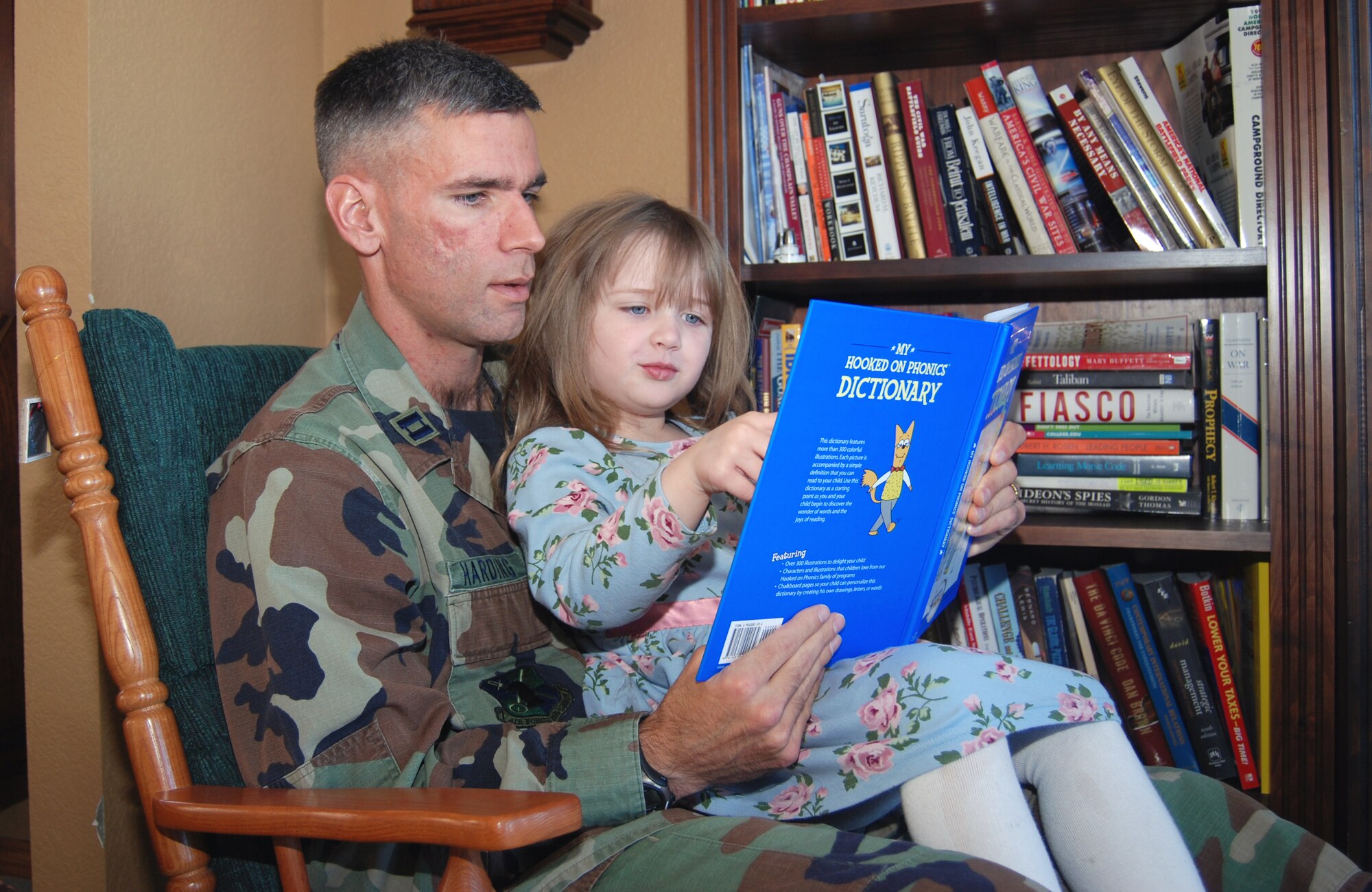 Capt. Daniel Harding, from the 544th Intelligence Group, reads with his 5-year-old daughter in his home in Colorado Springs.