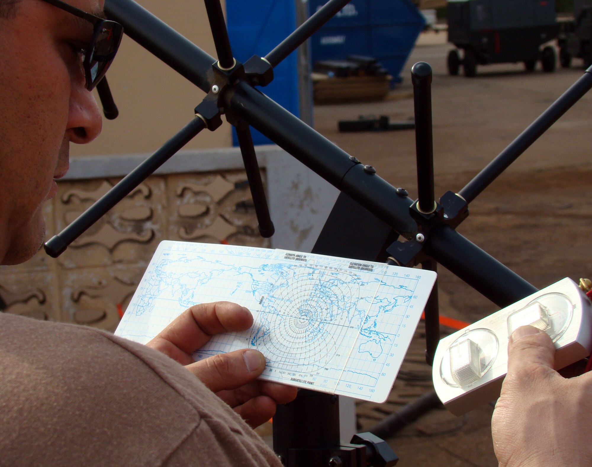 ACCRA, Ghana – Master Sgt. James Puente, aerospace ground equipment craftsman, checks direction and azimuth with the map and lensetic compass Feb. 17. Sergeant Puente will use the readings to determine which way to point the Ultra-High Frequency Antenna for optimum signal. The Airman is deployed to the African continent as part of a multi-service team to provide support for President George Bush’s five-nation visit.