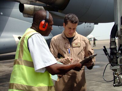 ACCRA, Ghana – Staff Sgt. Matthew Smith, a flying crew chief from the 437th Aircraft Maintenance Squadron at Charleston AFB, S.C., signs off on refueling paperwork for a C-17A Globemaster Feb. 15 with Paul Adrah, supervisor with Total Petroleum Ghana Ltd.  The Airman was part of the airlift team bringing people and equipment to various locations on the African continent in support of President George Bush’s five-nation visit.