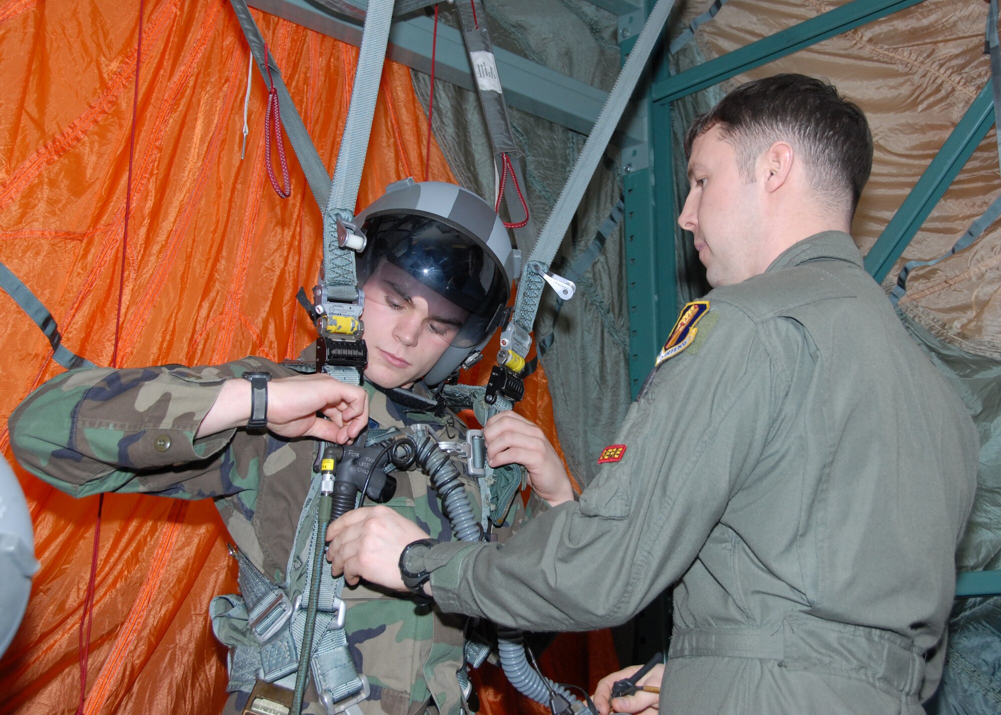 MISAWA AIR BASE, Japan -- Tech. Sgt. Gregory Adams, 35th Operations Support Squadron Survival, Evasion, Resistance, and Escape Specialist, helps Senior Airman Travis Twigg, 35th Civil Engineer Squadron engineering assistant, into the parachute simulator harness here Feb. 19, 2008. Airman Twigg had to undergo ejection training prior to taking an incentive flight on the F-16 fighter jet. (U.S. Air Force photo by Staff Sgt. Rachel Martinez)