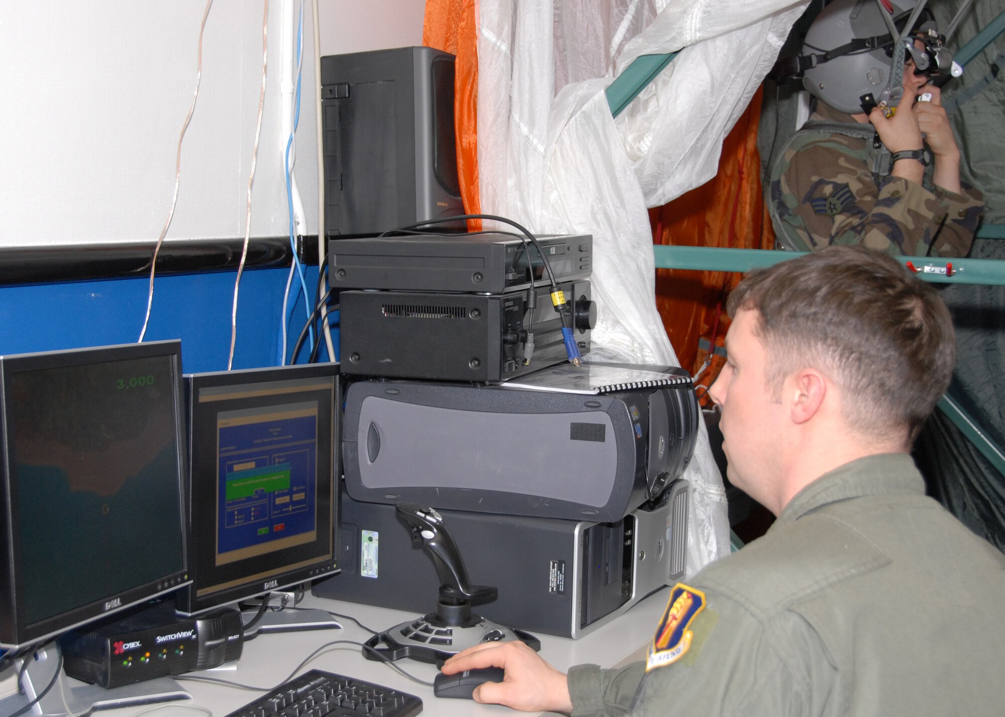 MISAWA AIR BASE, Japan -- Tech. Sgt. Gregory Adams, 35th Operations Support Squadron Survival, Evasion, Resistance, and Escape Specialist, monitors a virtual jump for Senior Airman Travis Twigg, 35th Civil Engineer Squadron engineering assistant, here Feb. 19, 2008. The parachute simulator allows program monitors to see what the jumper sees and make corrections if necessary. (U.S. Air Force photo by Staff Sgt. Rachel Martinez)
