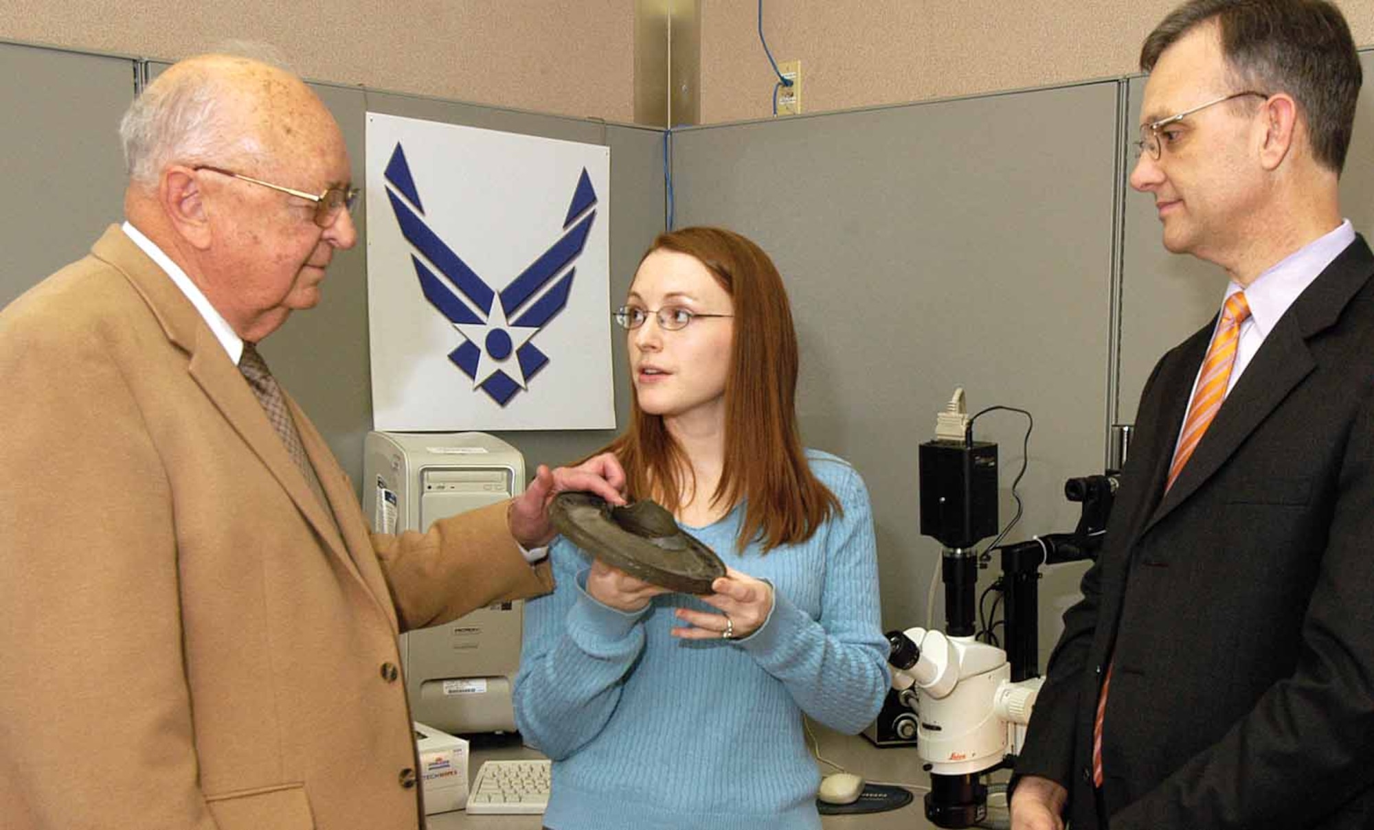 Russ Howard, right, director of the Engineering and Technical Management Directorate, listens as engineers Richard Shirley and Jennifer Tromble discuss types of work done in the Materials Lab of Physical Sciences.  Mr. Shirley brings almost 50 years of experience to his role as chief of the Physical Science Laboratory, overseeing five sections.  Ms. Tromble joined Tinker as a metallurgical engineer two years ago and represents the “future of the labs”, said Mr. Shirley.  All are preparing for Engineering Week which starts Sunday.  (Air Force photo)