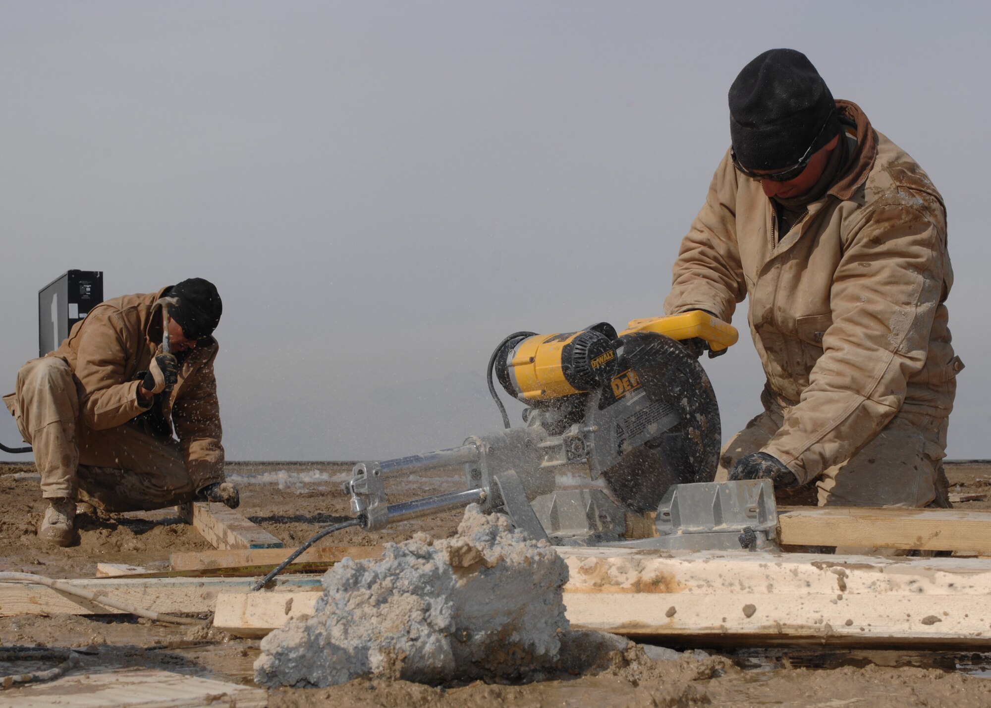 Staff Sgt. Levesque Lucas cuts wood with a saw while Senior Airman Jeffrey Ratliff hammers wood to be used during the construction of a barrier arresting kit on the flightline at Bagram Air Base, Afghanistan, Feb. 13. Sergeant Levesque is from 819th RED HORSE Squadron, Malmstrom Air Force Base, Mont. and is deployed to 1st Expeditionary RED HORSE Group as a structural craftsman. Airman Ratliff is also from the 819th RED HORSE Squadron, Malmstrom AFB, Mont. and is deployed to 1st Expeditionary RED HORSE Group as a structural journeyman. (U.S. Air Force photo/Master Sgt. Demetrius Lester) 