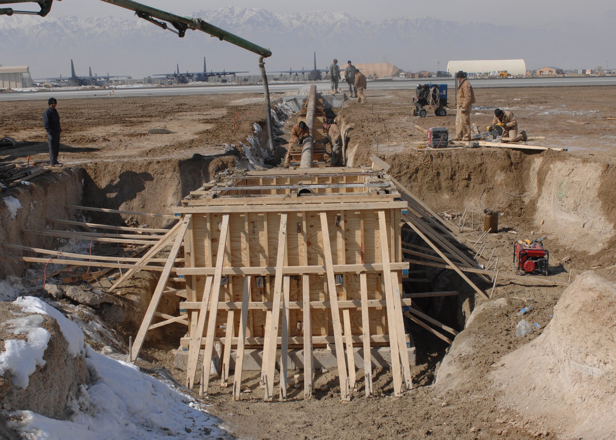 Airmen from the 1st Expeditionary RED HORSE Group work construction on a new barrier arresting kit at Bagram Air Base, Afghanistan, Feb. 13. Once the BAK 12 is finished, it will be used to stop aircraft with tail hooks that have hydraulics or brake problems. The BAK 12 system is scheduled to be complete by mid-March. (U.S. Air Force photo/Master Sgt. Demetrius Lester) 