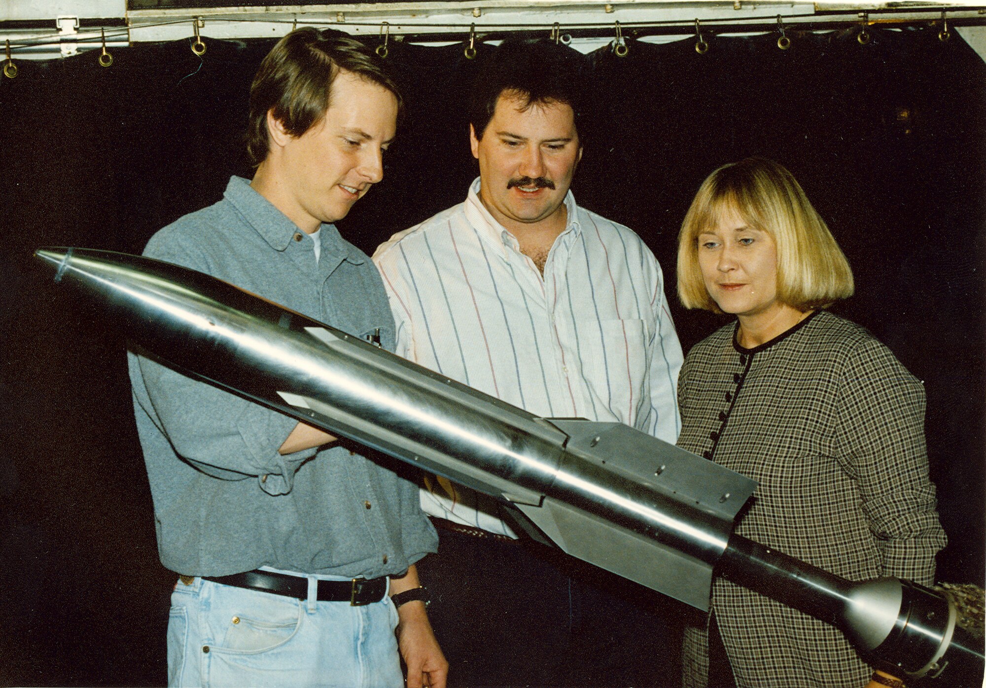 (From left) Gregg Fox, Aerospace Testing Alliance tunnel installation engineer, Andy Davenport, former center lead engineer and Sherry Simons, ATA project engineer, inspect the 1/3 scale model of the third stage Navy Standard Missile in AEDC's von Karman Gas Dynamics Facility Wind Tunnel A in 1996. They were gathering limited aerodynamic data for the customer’s database. (AEDC file photo)
