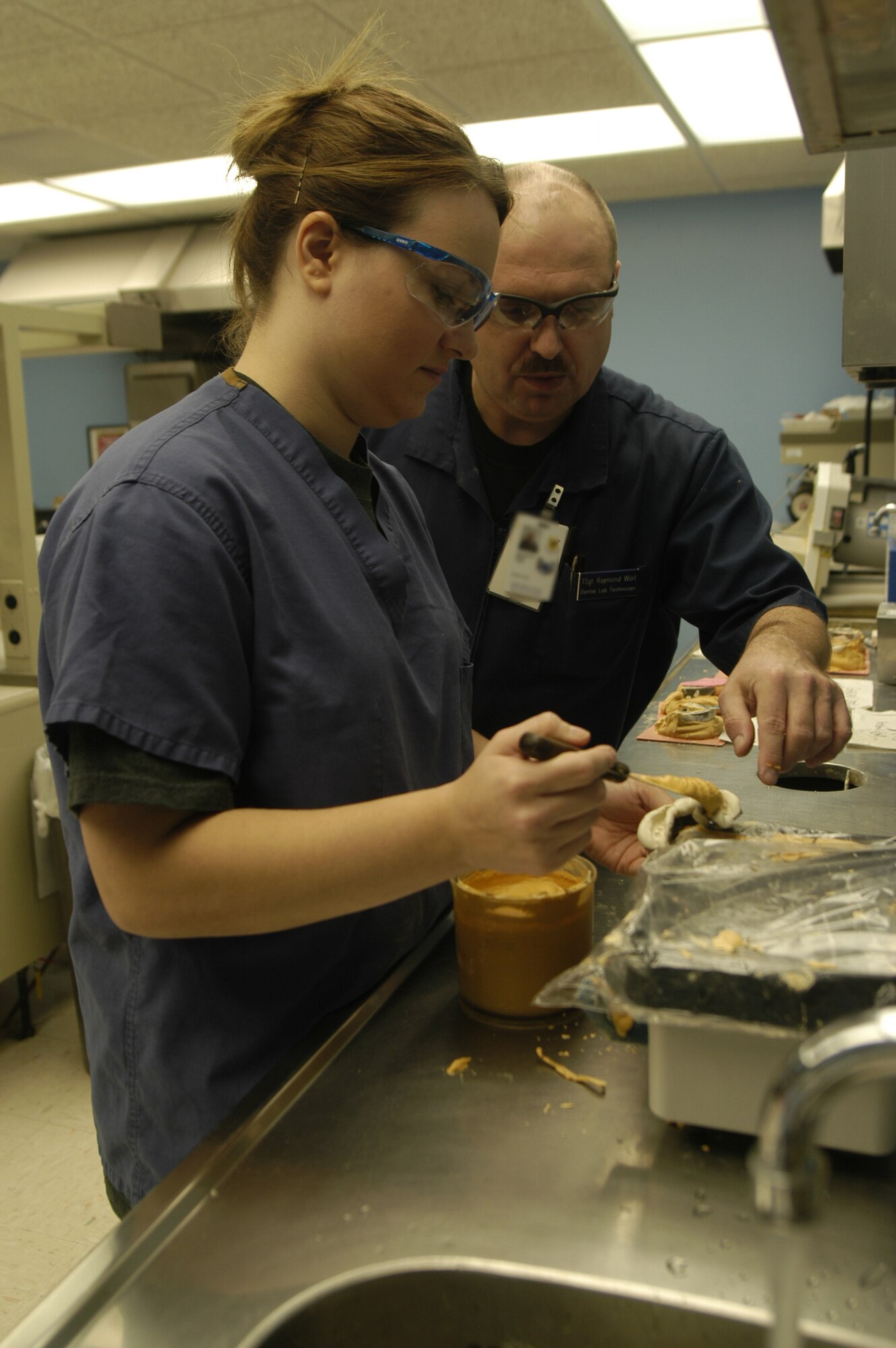 Tech. Sgt. Raymond Worl, 436th Aerospace Medicine Squadron NCO in-charge of dental laboratory, helps Kristin Dixon, a dental hygienist student from the Delaware Technical and Community College, as she pours an impression to make a stone model of teeth. Delaware Technical students come to Dover Air Force Base monthly to accomplish on-the-job training with Sergeant Worl where the students learn how to fabricate sports guards, fluoride and bleaching trays. (U.S. Air Force photo/ Airman 1st Class Shen-Chia Chu)
