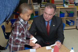 LANGLEY AIR FORCE BASE, Va. -- Jason Smithson, son of Tech. Sgt. Jason Smithson, 1st Equipment Maintenance Squadron, presents cards to Gov. Tim Kaine during his visit to the Russ  Child Development Center Feb. 20. Jason is one of 18 Langley children who are part of Gov. Kaine’s Start Strong Initiative, which teams Virginia communities with private, faith-based, home-based and military providers in an effort to provide quality education experiences for 4-year-olds. Gov. Kaine visited the CDC to see the children, discuss pre-kindergarten initiatives and budget proposals. (U.S. Air Force photo/Staff Sgt. April Wickes)