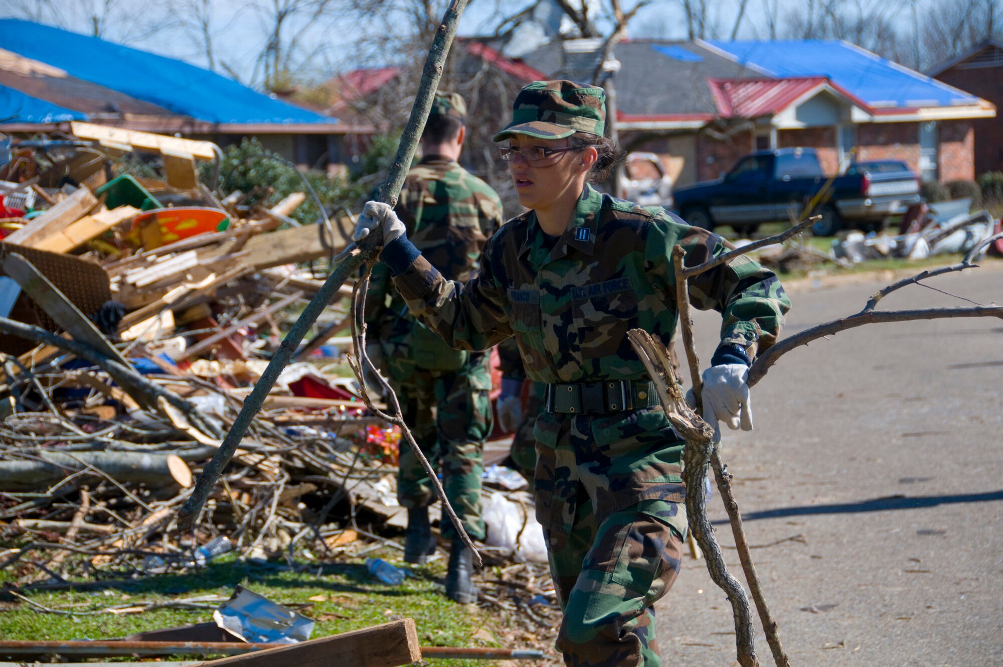Officer Trainee Rosalva Franco clears debris Feb. 19  after a Feb. 17 tornado ripped through Prattville, Ala. More than 65 Officer Training School basic officer trainees and 20 other Airmen assigned to Maxwell Air Force Base, Ala., volunteered to help organize and clear debris from the city located 15 miles northwest of the base. Latest estimates indicate that more than 150 home were destroyed and 760 homes were damaged in a series of storms that created 150 mph winds. Of those homes, approximately 25 military homes were destroyed and 170 were damaged. (U.S. Air Force photo/Master Sgt. Scott Moorman) 
