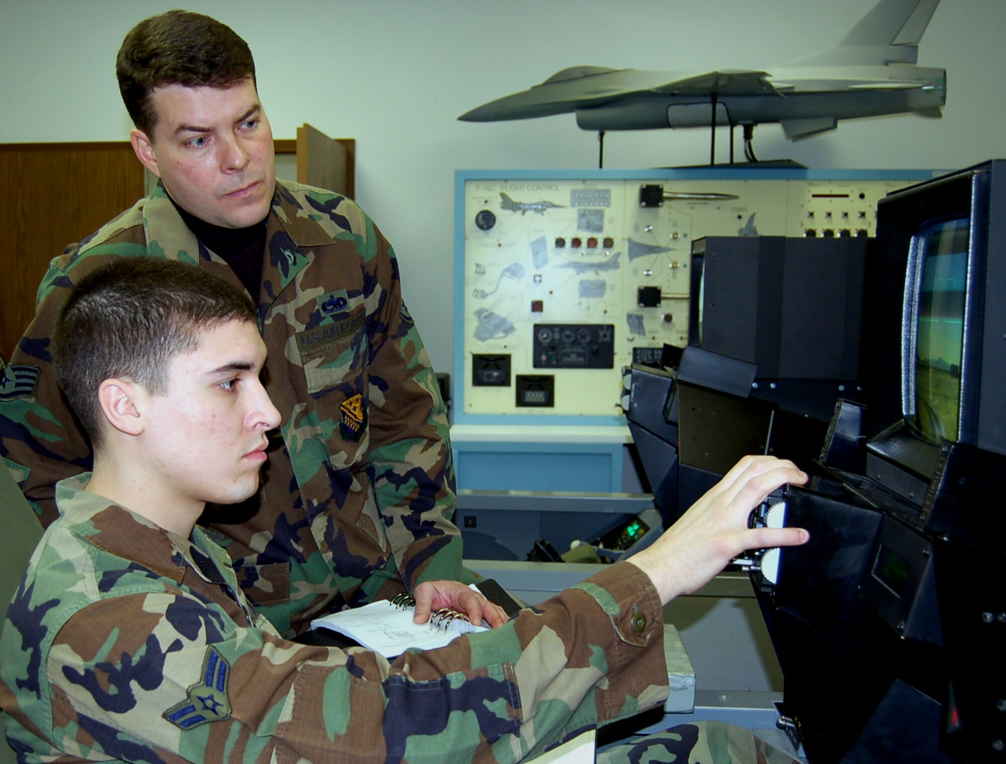 SPANGDAHLEM AIR BASE, Germany – Airman 1st Class John Cardini, 23rd Aircraft Maintenance Unit, runs through an F-16 global positioning system training scenario while Staff Sgt. Staff Sgt. Steve Zarecki, 372nd Training Squadron instructor, observes. (U.S. Air Force photo/Staff Sgt. Tammie Moore)