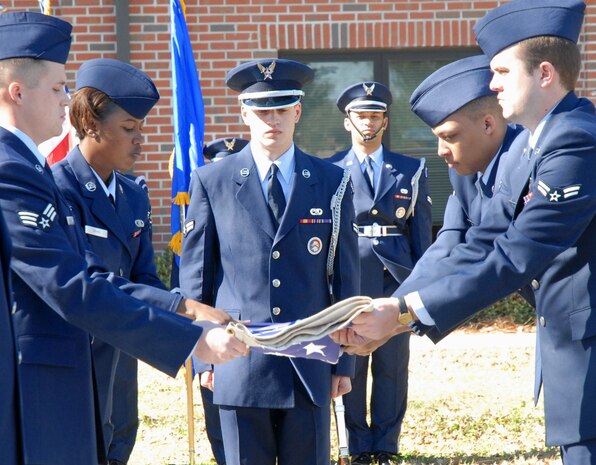Base Airmen perform a flag-folding ceremony during the Basic Honors and Ceremony Course graduation Feb. 19. Senior Airman Joshua Starks, 437th Aerial Port Squadron, Airman 1st Class Lauren Ross, 437th Operations Support Squadron, Senior Airman Jaron Brown and Airman 1st Class Ross Ledonne, both from the 16th Airlift Squadron, participated in the week-long class to learn about the different ceremonies Honor Guard members take part in. (U.S. Air Force photo/Staff Sgt. Jennifer Arredondo)