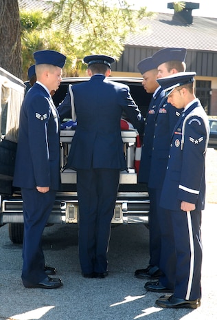 Graduating and current Honor Guard members take a casket from a Hearst during a mock burial ceremony on Charleston AFB Feb. 19.  The graduating members participated in the ceremony as part of the requirements to graduate from the Honor Guard Basic Protocol Honors and Ceremony Course. (U.S. Air Force photo/Staff Sgt. Jennifer Arredondo)