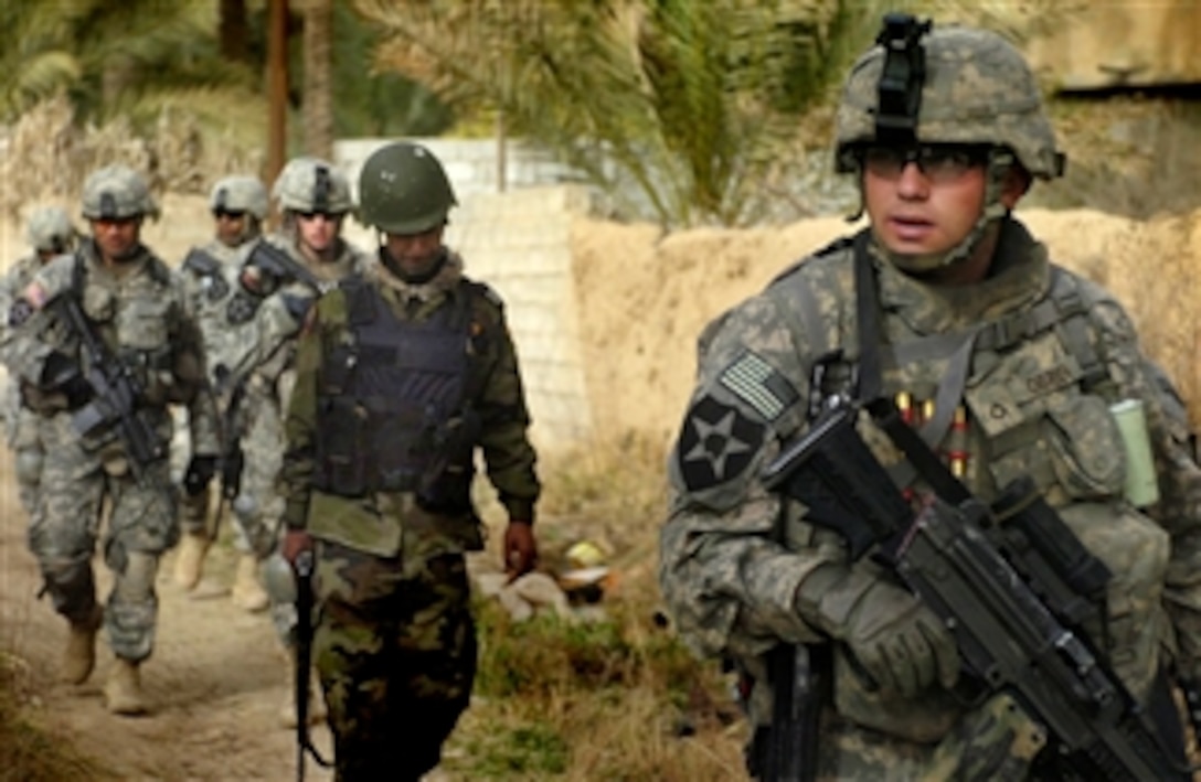 U.S. Army Pfc. Toby Obrien and other soldiers assigned to the 38th Infantry Regiment's 1st Battalion, Company C patrol Aswad, Iraq, with Iraqi policemen, Feb. 19, 2008, during Operation Chaos Thrasher. 