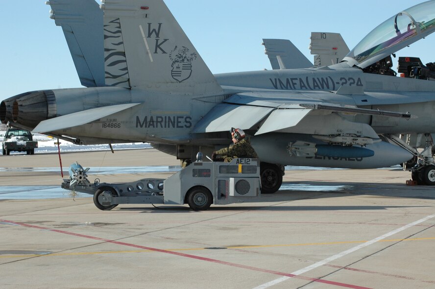 A Marine All-Weather Fighter Attack Squadron 224 ordnance crew member loads a 2,000-pound bomb onto an F/A-18 in preparation for a training mission at the Utah Test and Training Range. Hill welcomed the Beaufort, S.C. unit in January for training in a cold weather climate and working with live munitions. (U.S. Air Force photo by Deanna Shallenberger) 