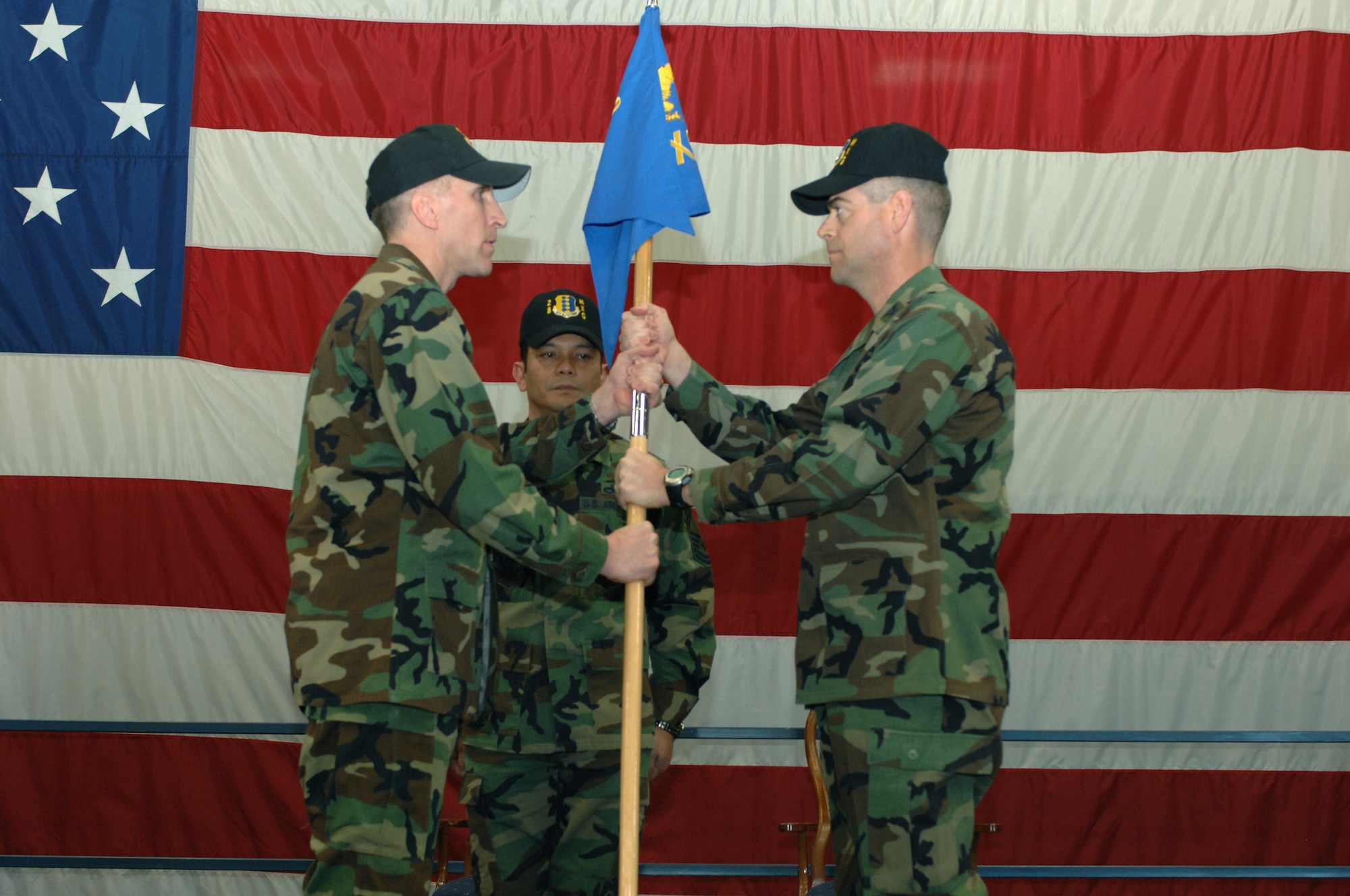 Col. Scott Vander Hamm, 28th Bomb Wing commander, passes the 28th Maintenance Group flag to Col. Thomas Fitch who assumes command of the 28th Maintenance Group Feb. 22.  Chief Master Sgt. Kenneth Charfauros assists in the passing of the 28th Maintenance Group flag during Col Fitch's assumption of command ceremony.  (U.S. photo/Airman 1st Class Adam Grant)