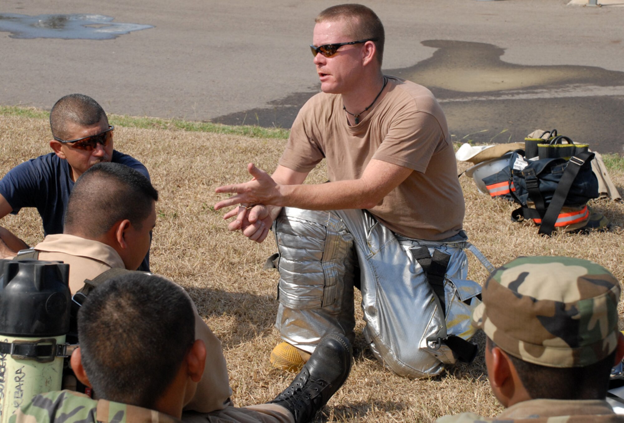 Air Force Staff Sgt. Dustin Jackson, JTF-Bravo firefighter, provides advice for Honduran firefighters just coming out of the Joint Task Force-Bravo ?burn house,? a two-level training structure used to provide firefighters with a realistic firefighting experience. The firefighters are participating in a JTF-Bravo-sponsored firefighting subject matter expert exchange. (U.S. Air Force photo by Tech. Sgt William Farrow)