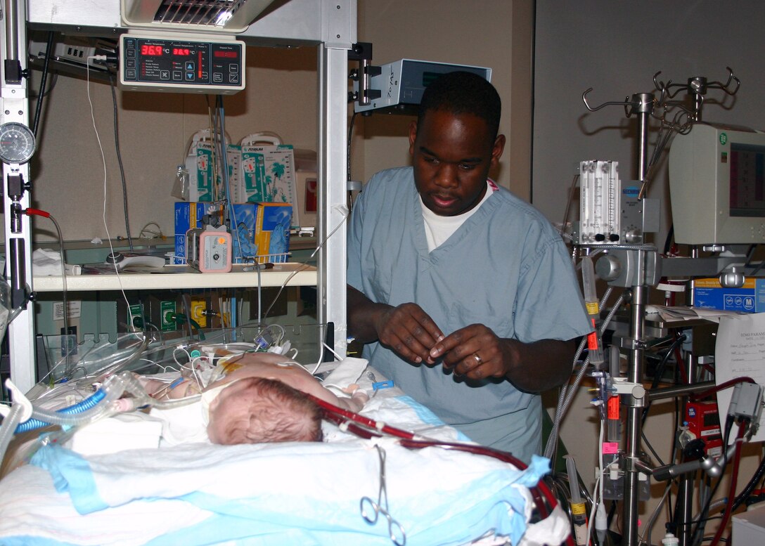 Capt. Moayad Fowler, a registered nurse in the 59th Medical Wing, checks Jacob Rambish's vitals Feb. 22 in the neonatal intensive care unit in Wilford Hall Medical Center at Lackland Air Force Base, Texas.  The 6-week-old infant was placed on heart/lung bypass equipment and transported to Wilford Hall Feb. 22 for advanced medical care.  (U.S. Air Force photo/Sue Campbell)