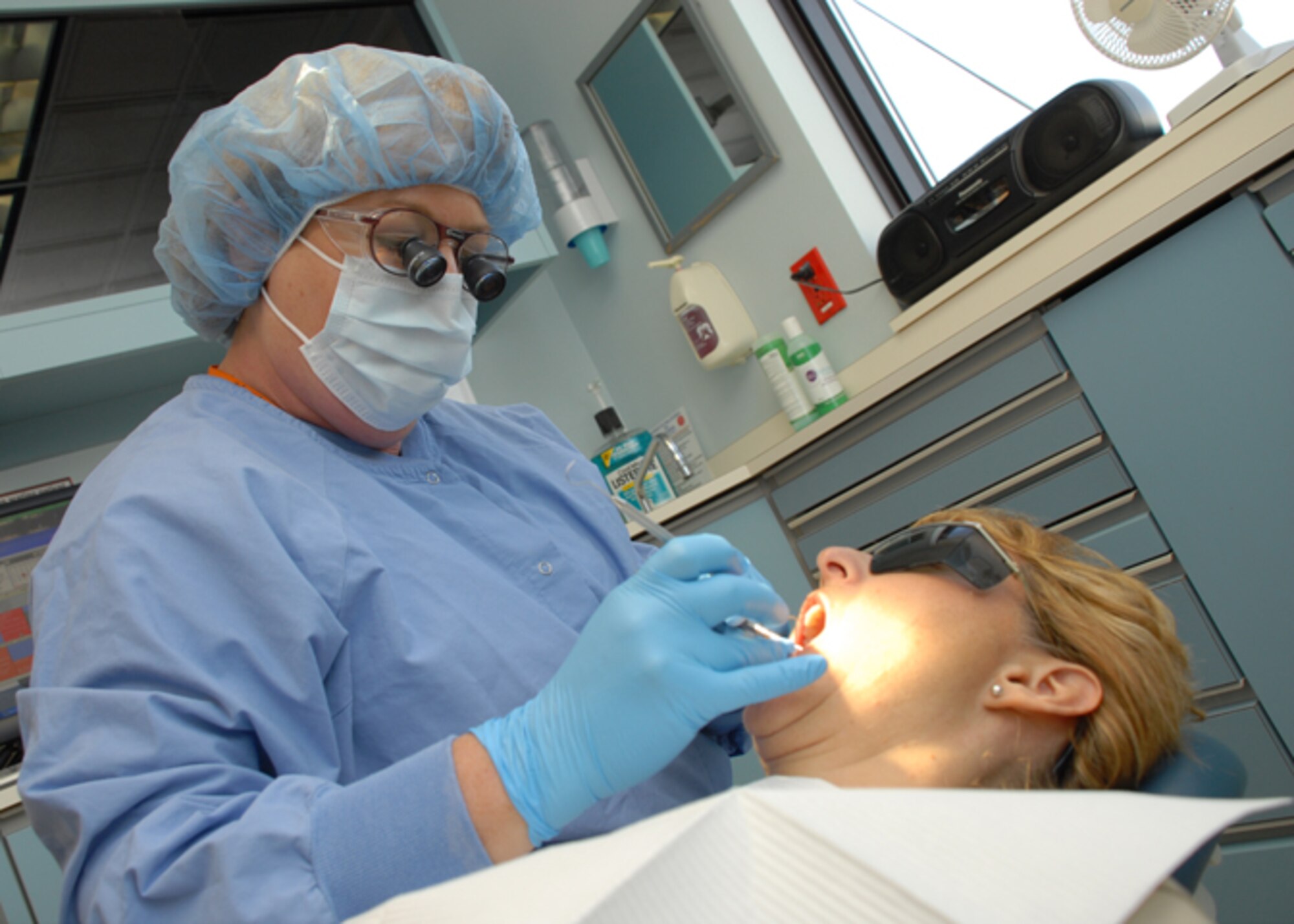 EGLIN AIR FORCE BASE, Fla. -- Jo Lowery, 96th Dental Squadron hygienist, works on a patient inside the dental clinic. Mrs. Lowrey was recently Civilain of the Year, category III for her dedication and professionalism on and off duty. Throughout the year, she performed more than 1,000 cleanings, out producing the next dental technician by 54 percent. Among her many accomplishments, she learned sign language to communicate with a co-worker, improving clinic relations. (U.S. Air Force photo by Staff Sgt. Mike Meares)