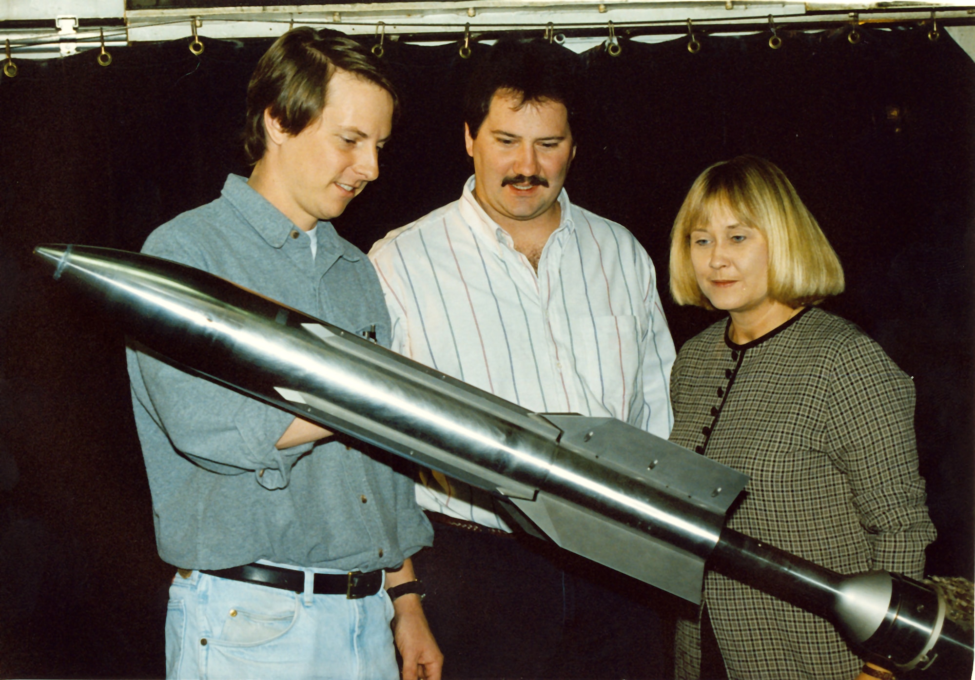 Gregg Fox (from left), Andy Davenport and Sherry Simons inspect the 1/3 scale model of the third stage Navy Standard Missile in Arnold Engineering Development Center's von Karman Gas Dynamics Facility Wind Tunnel A in 1996 at Arnold Air Force Base, Tenn. They were gathering limited aerodynamic data for the customer's database. Mr. Fox is an Aerospace Testing Alliance tunnel installation engineer, Mr. Davenport is a former center lead engineer, and Ms. Simmons is an ATA project engineer. (U.S. Air Force photo) 
