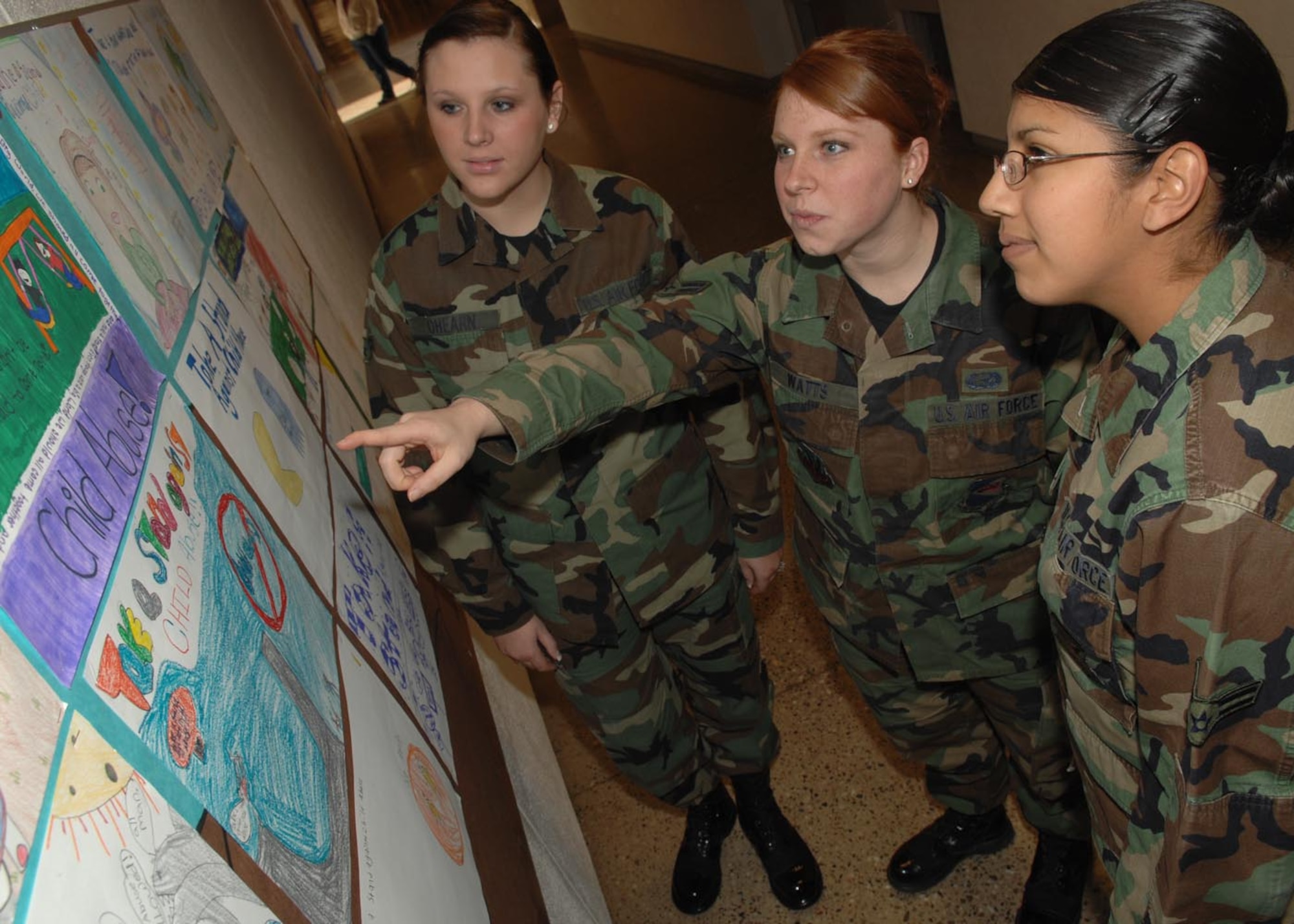 Airman 1st Class Rebecca OHearn, 355th Logistics Readiness Squadron, Airman 1st Class Stacey Watts, 355th Mission Support Group, and Airman 1st Class Stephanie Jara, Twelfth Air Force (AFSOUTH), judge posters made by fifth graders at Borman elementary school, as part of the Child Abuse prevention month. 